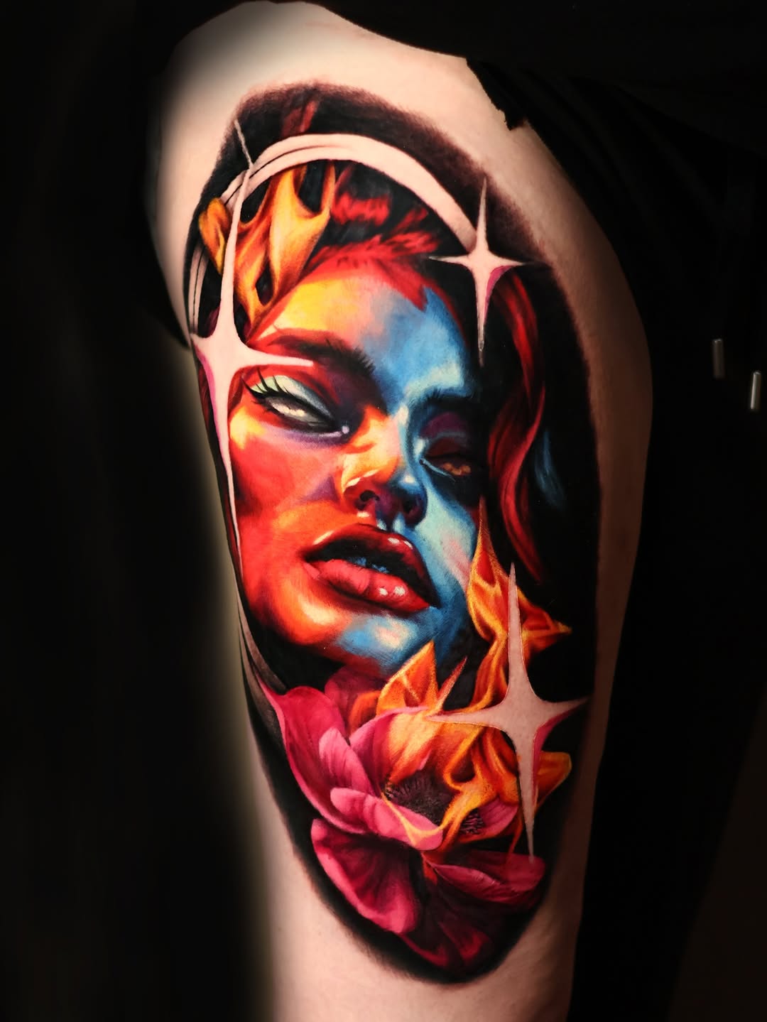 Woman's face with fire and flower surrealism tattoo on the shoulder by Júlia Sorrino