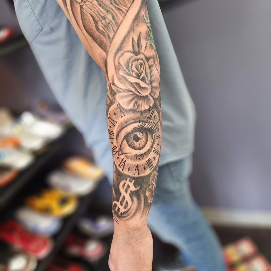 Eye and clock with rose realism tattoo on the forearm by Dennis Foust