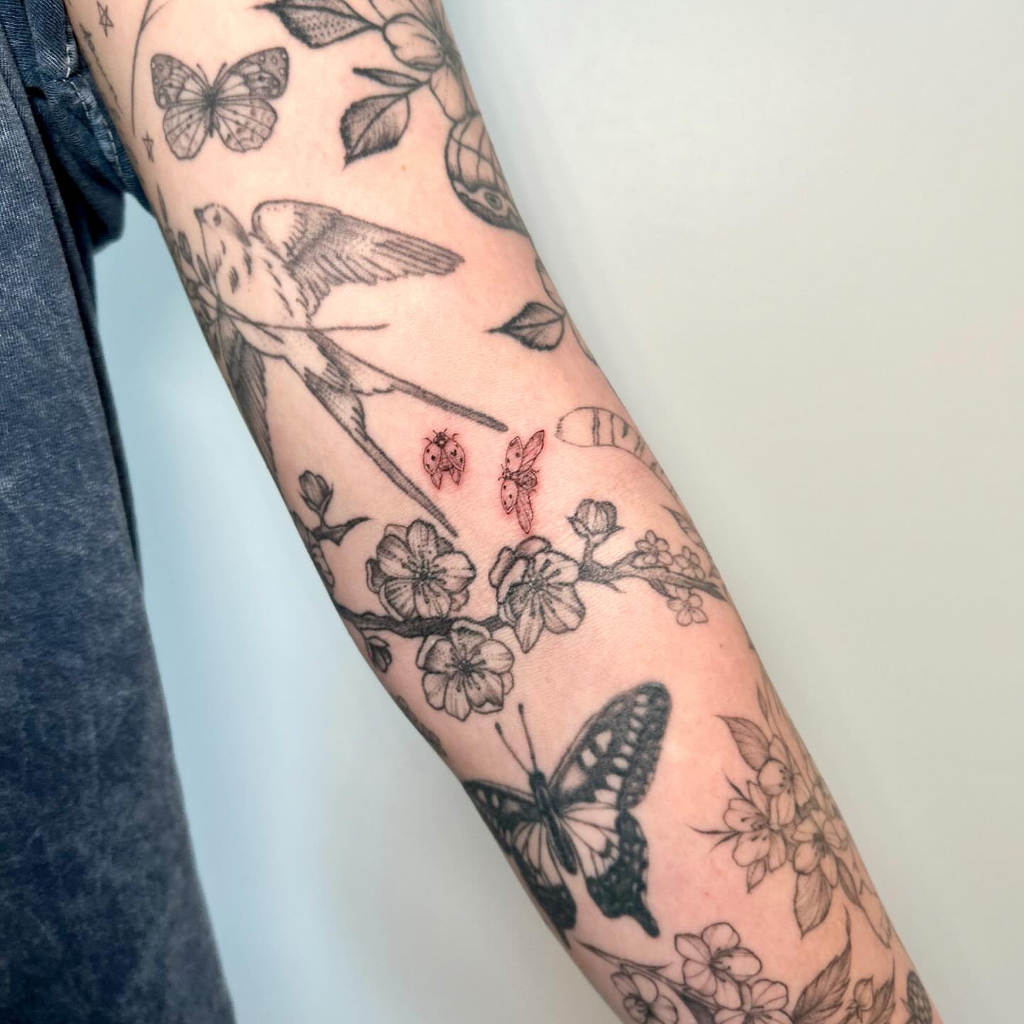Butterflies and flowers black and grey tattoo on the forearm by L i v π Tattoo Artist. AMITY TATTOO