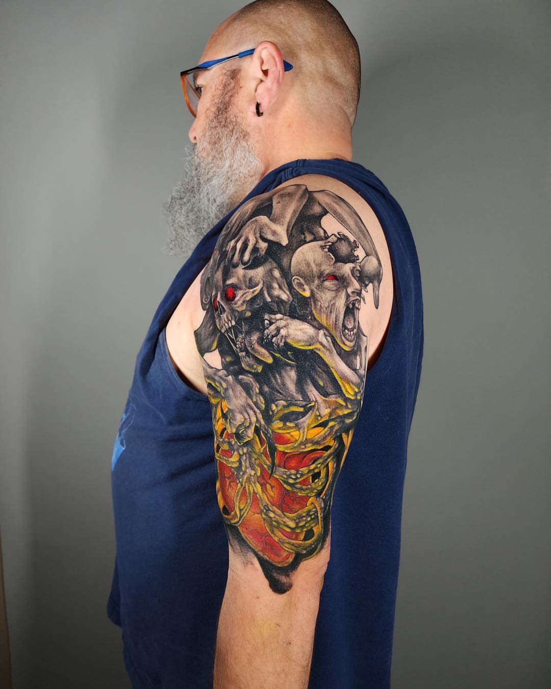 Demon dark realism tattoo on the upper arm by Tank Maass