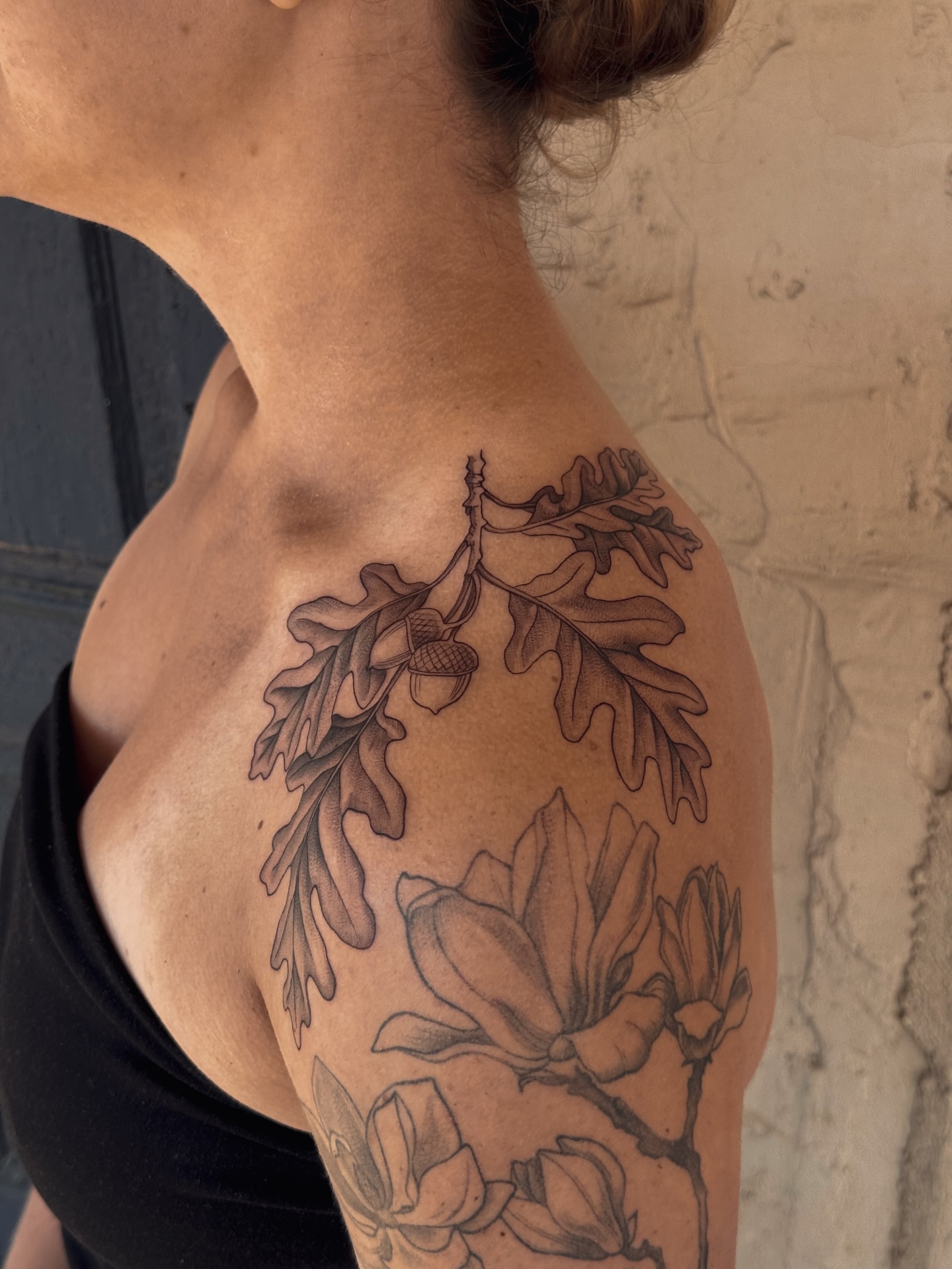 Oak branch and magnolia flowers realism tattoo on the shoulder by Floral