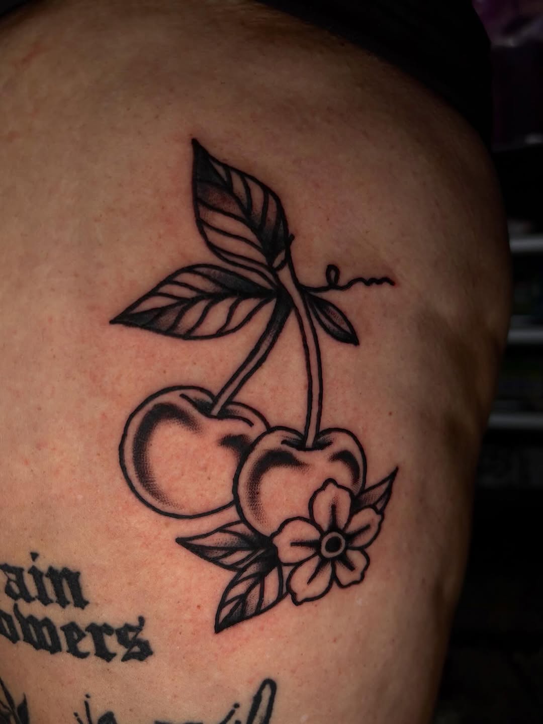 Cherries and flower tattoo on the shoulder by Jenna Clayton
