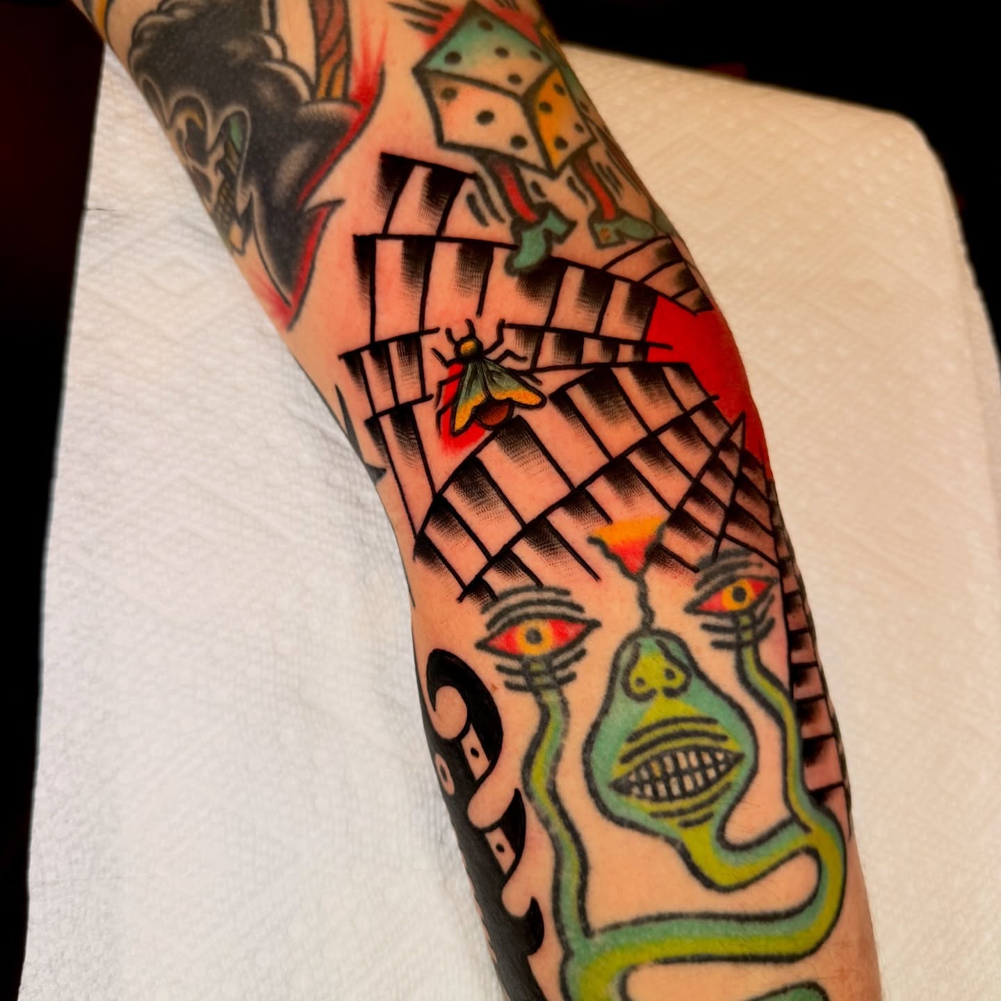 Abstract face American traditional tattoo on the forearm by {{Theo Glanton}}