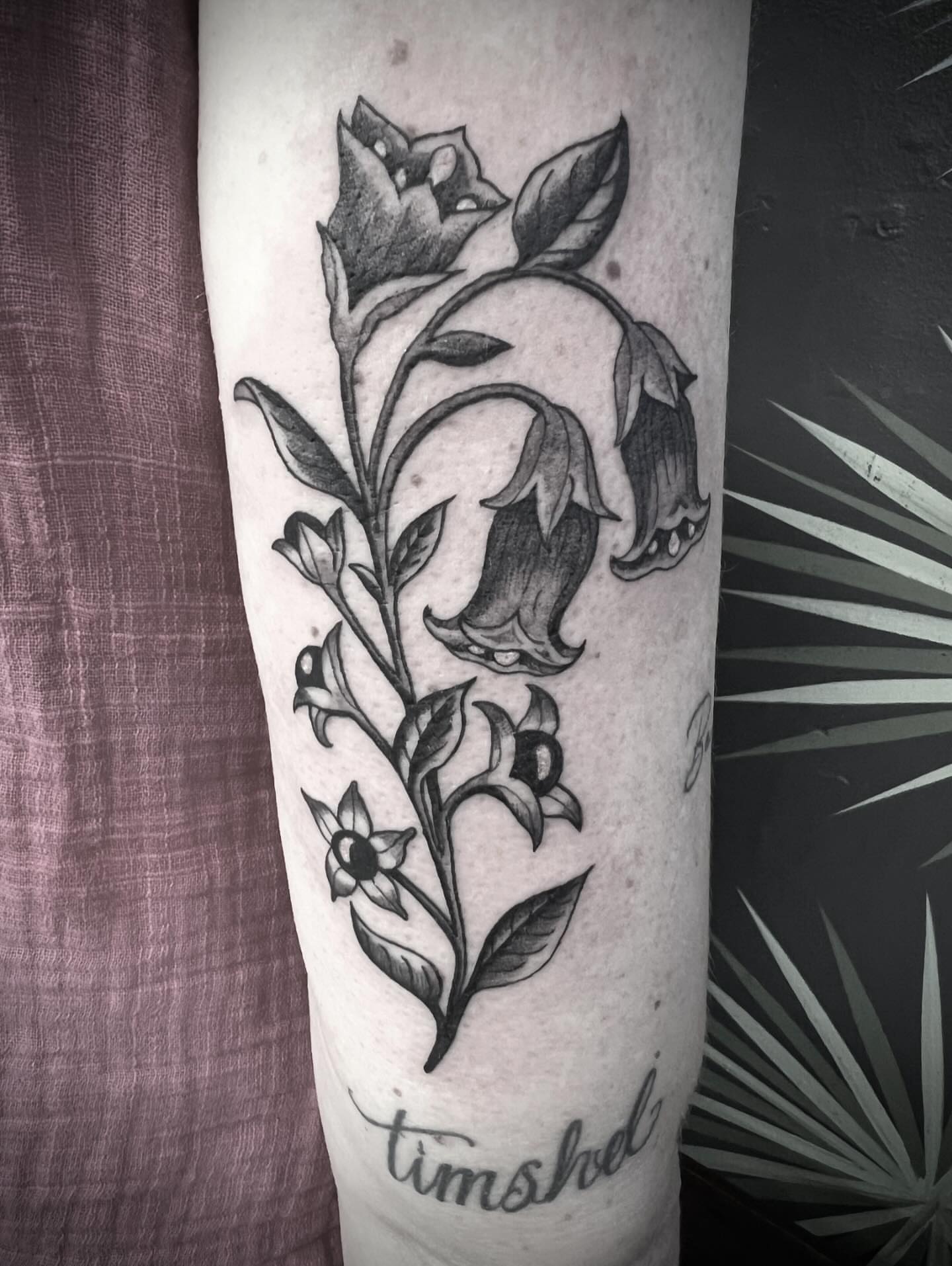 Bell flowers black and grey tattoo on the forearm by Natalie Phillips, Oakland, California