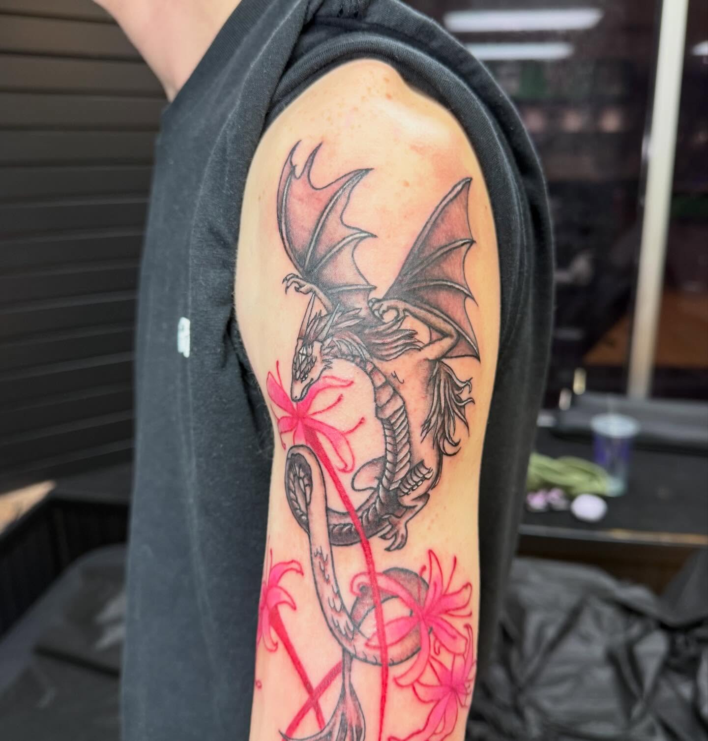 Dragon and flowers realism tattoo on the forearm by Nic