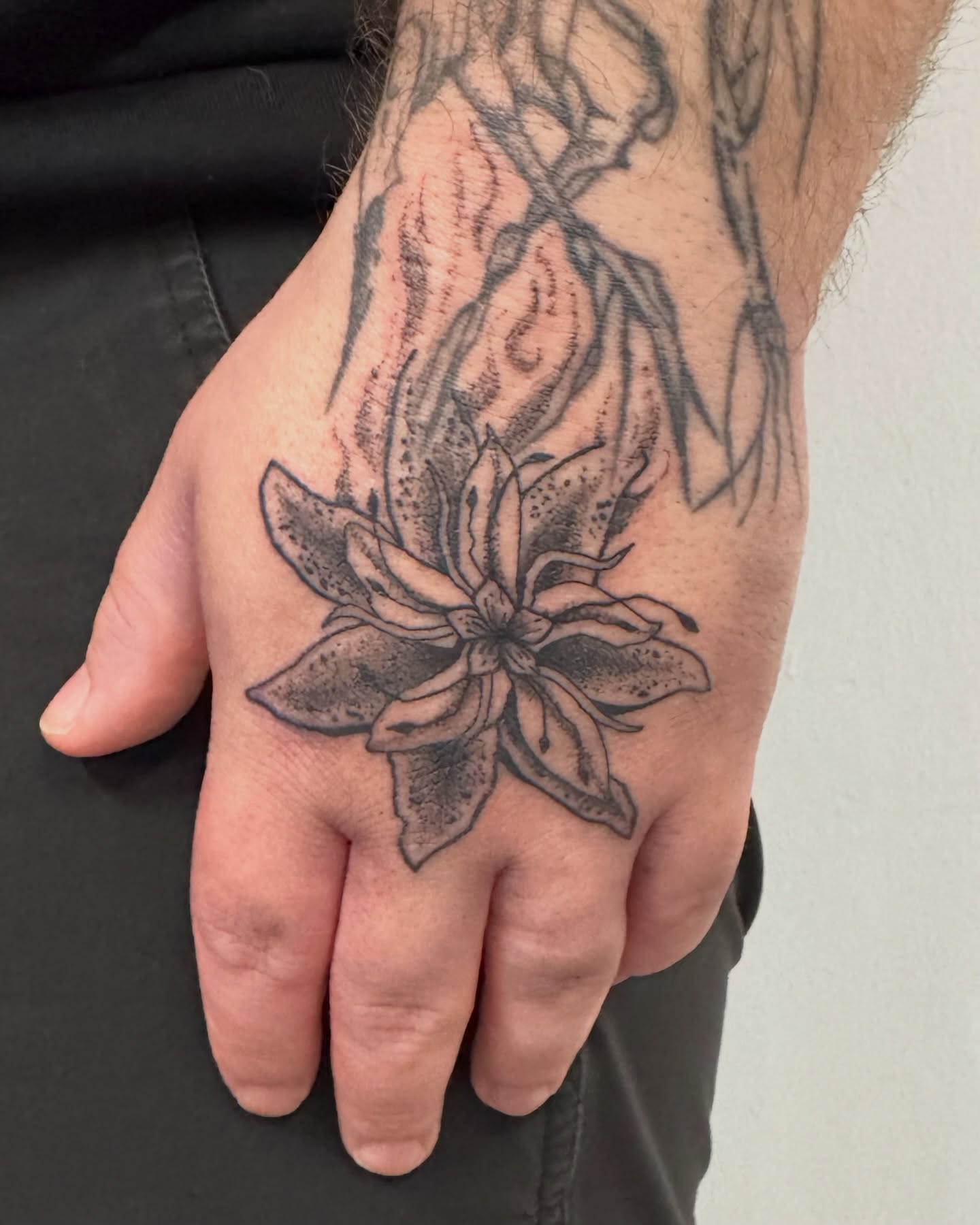 Flower black and grey tattoo on the hand by jake.inks