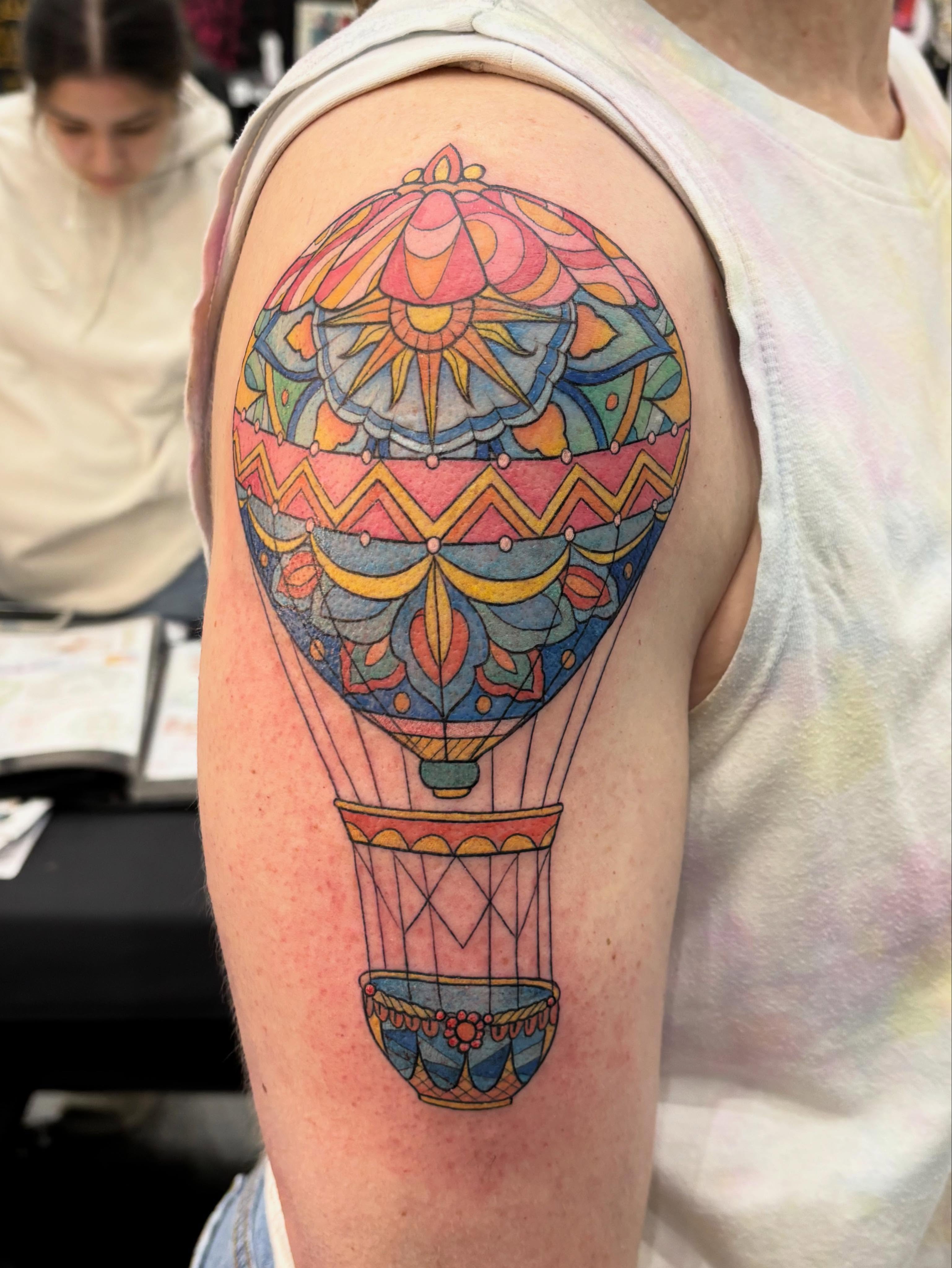 Hot air balloon geometric tattoo on the upper arm by Jennifer Flores
