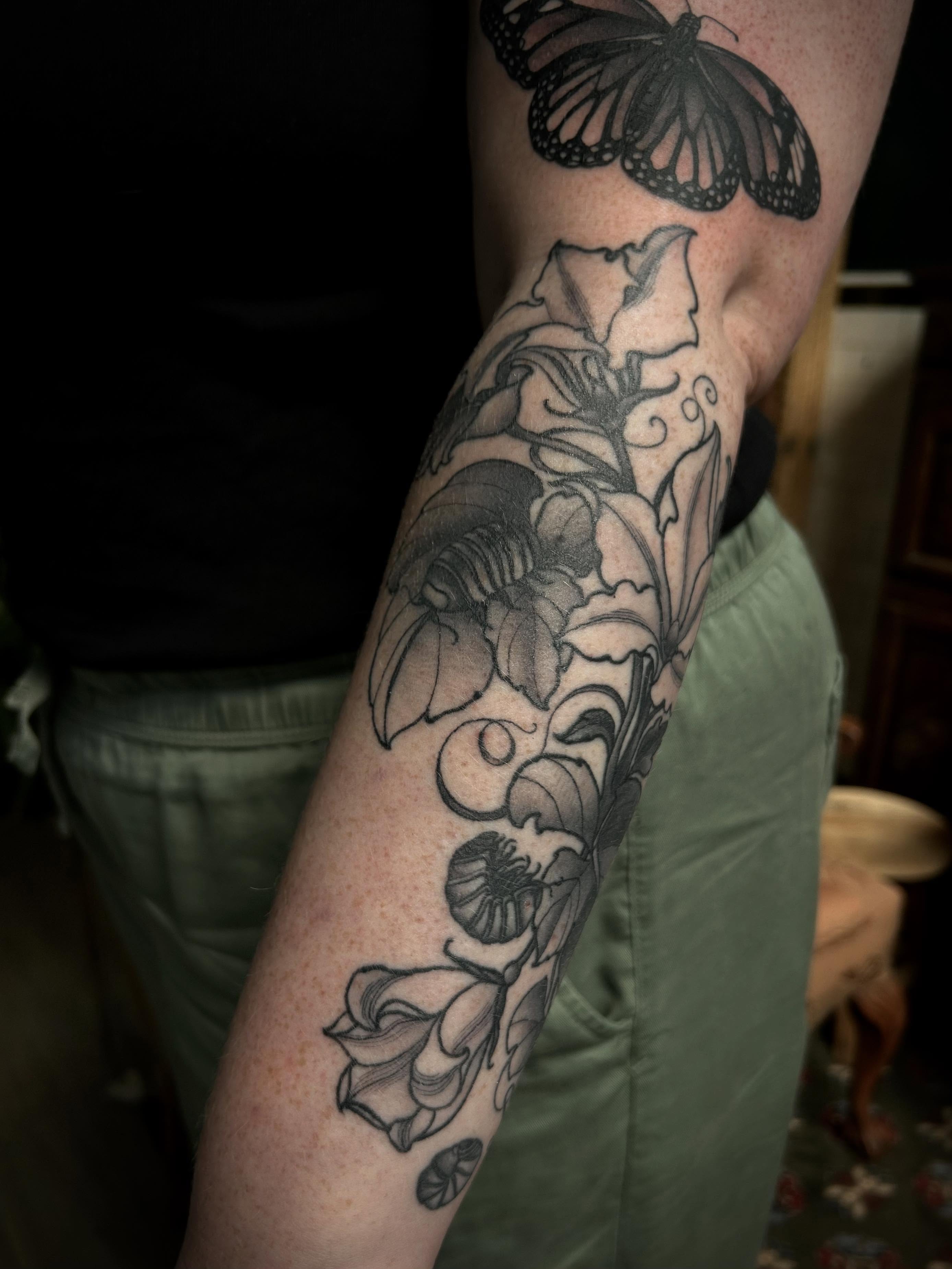 Floral and butterfly black and grey tattoo on the forearm by ꧁𝙺𝚊𝚛𝚒𝚗𝚊꧂, Grinnell, Iowa