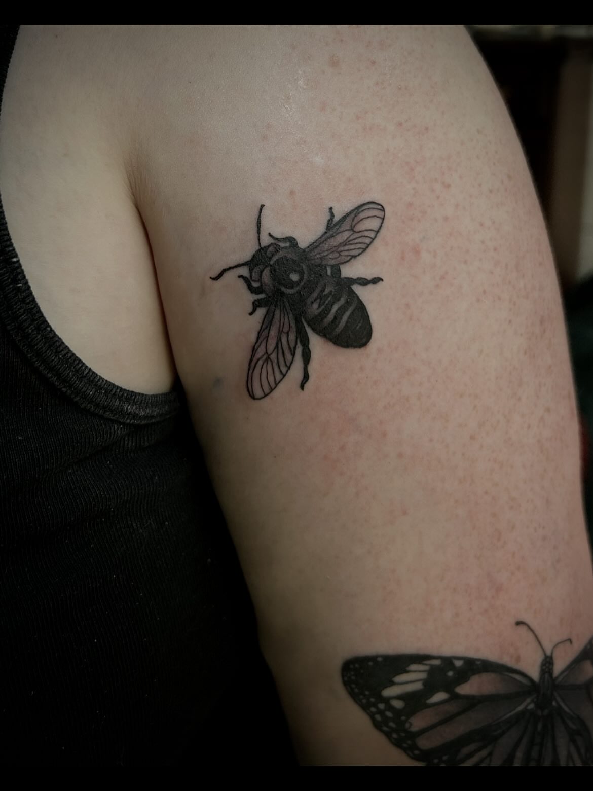 Bee black and grey tattoo on the upper arm by ꧁𝙺𝚊𝚛𝚒𝚗𝚊꧂, Grinnell, Iowa