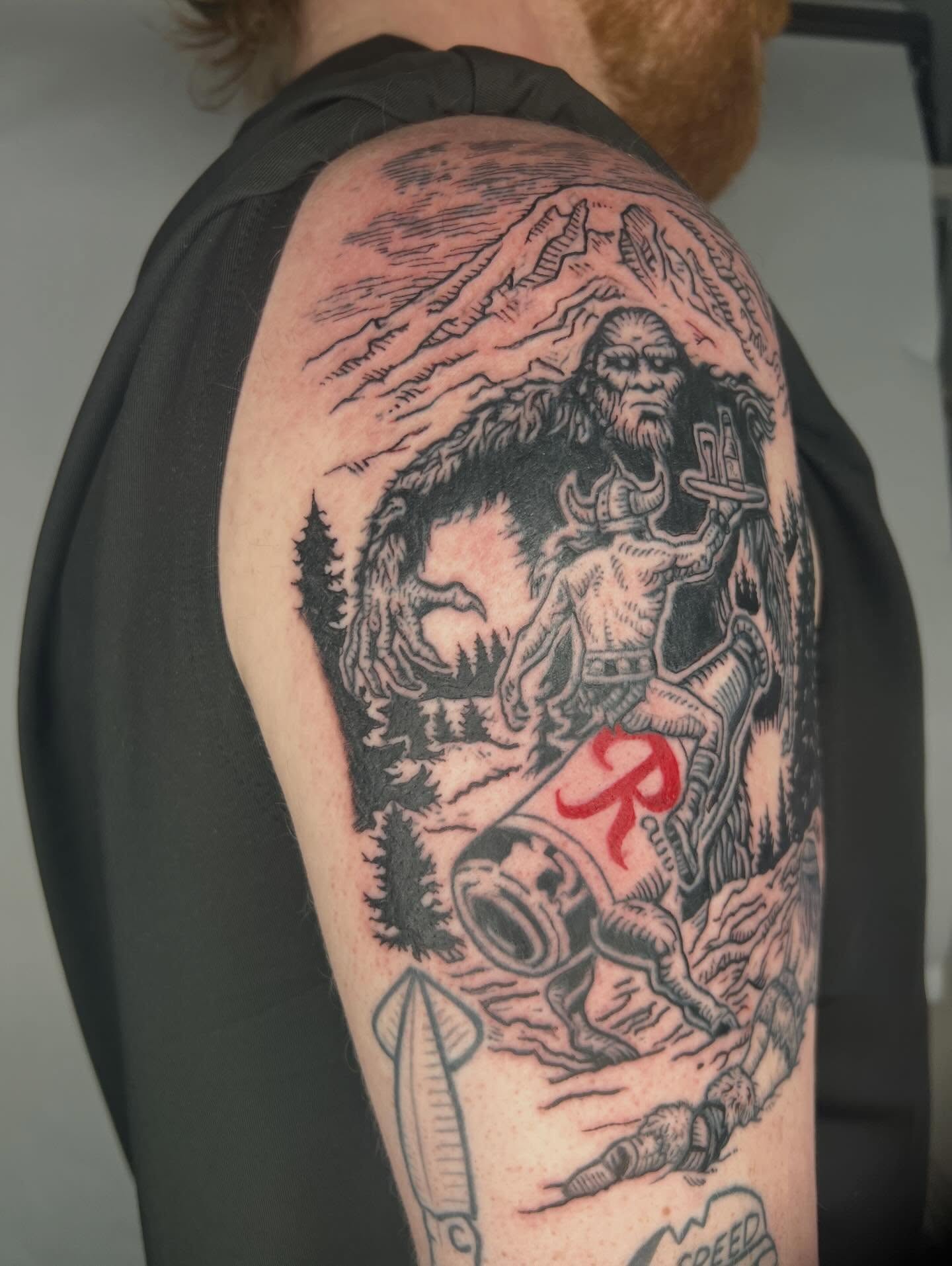Mountain and creature realism tattoo on the shoulder by Jason Middelton