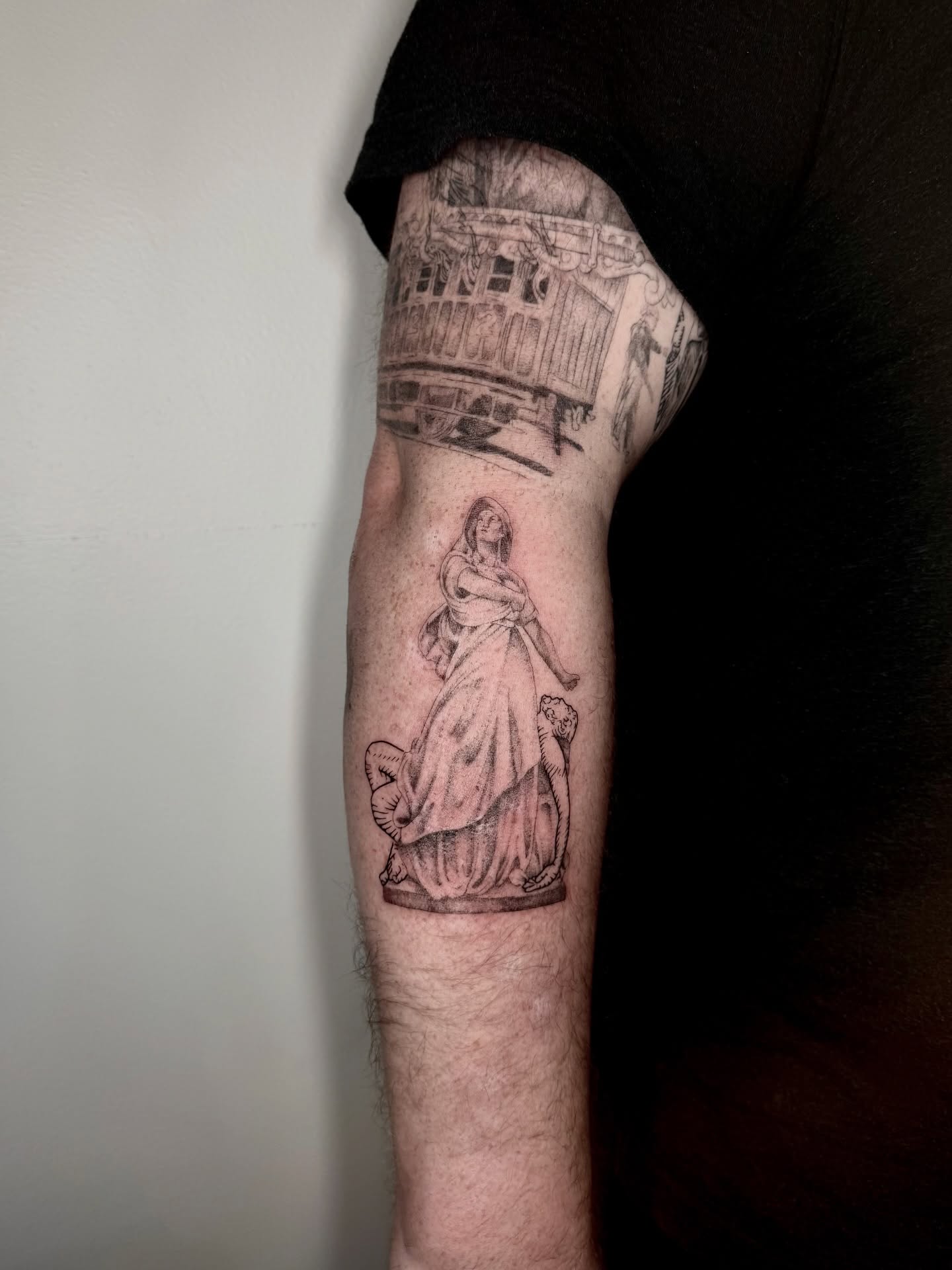 Woman in dress black and grey tattoo on the forearm by Ian Saner