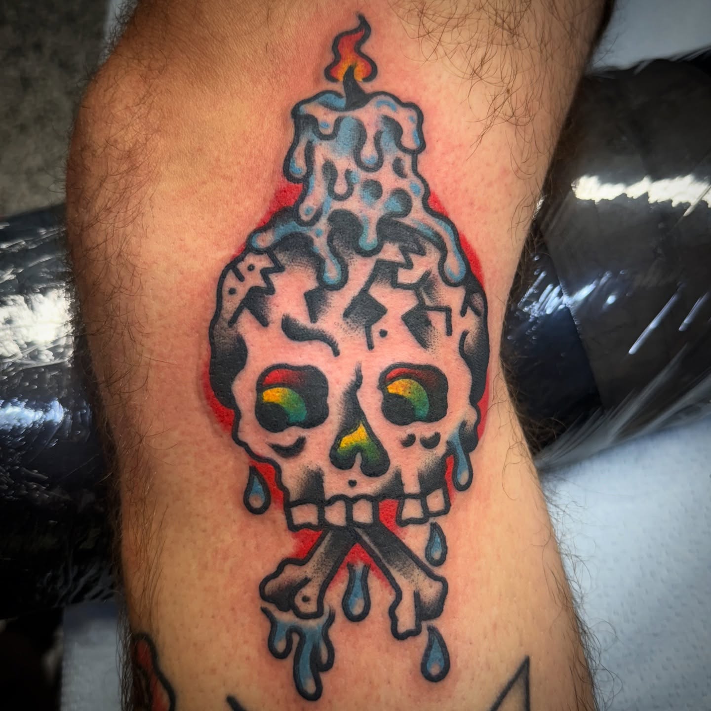 Melting skull candle American traditional tattoo on the thigh by Chuck Paprocki, Nashville, Tennessee