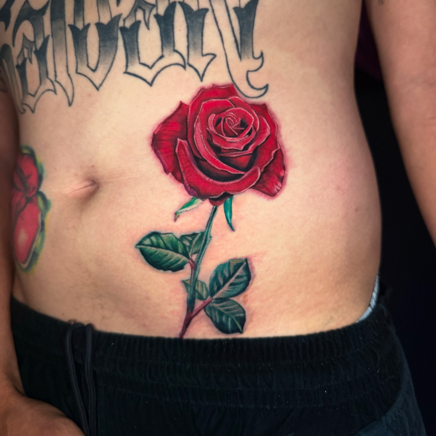 Red rose realism tattoo on the torso by Goga