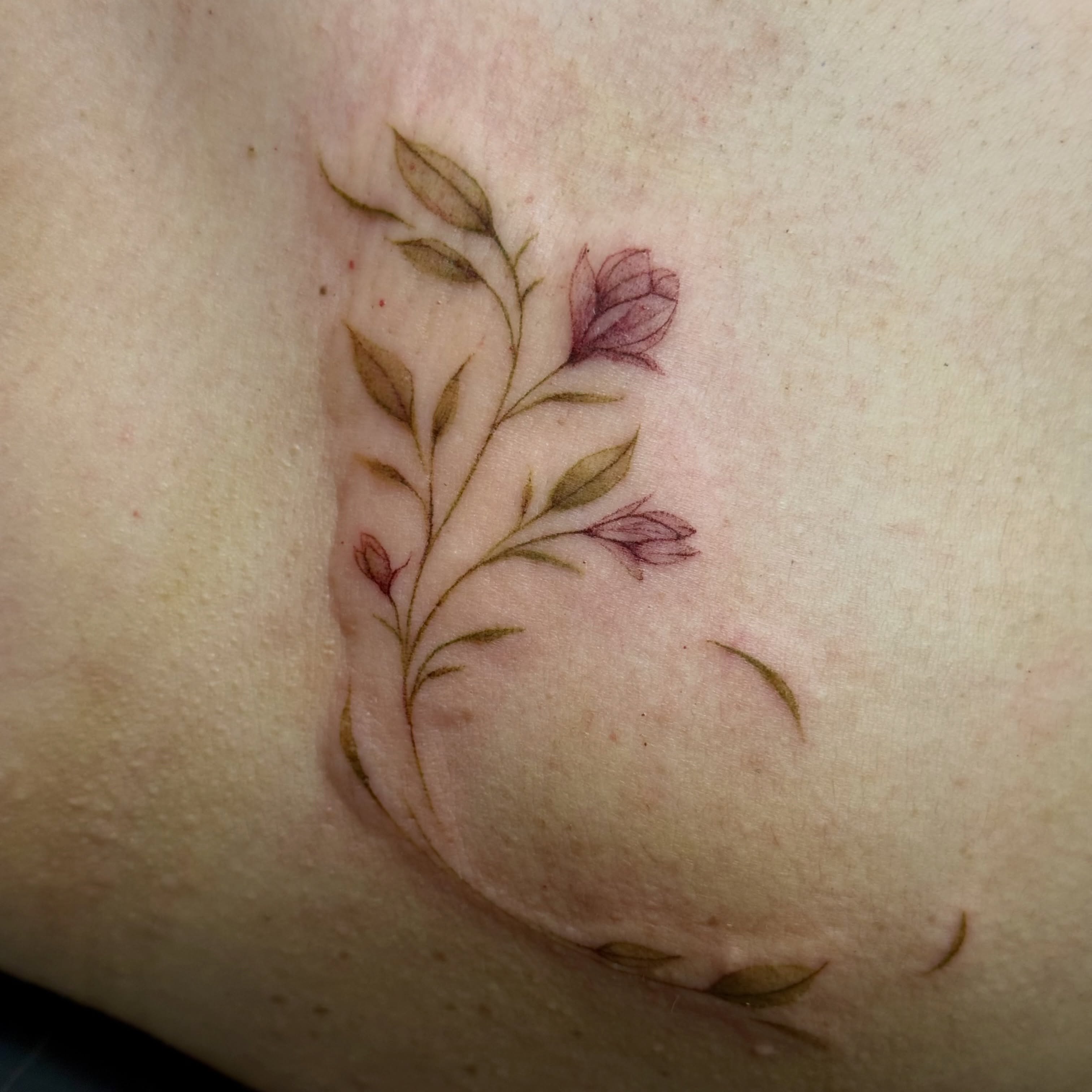 Floral vine fine line tattoo on the thigh by Ava De La Torre
