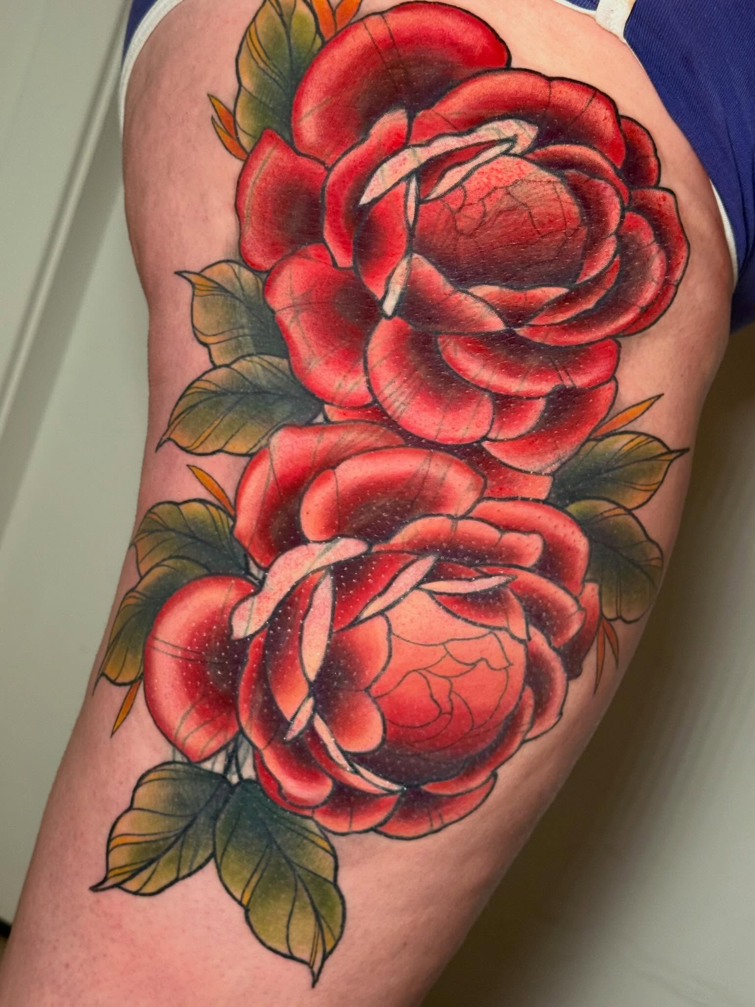 Red roses American traditional tattoo on the thigh by Kayla Warren