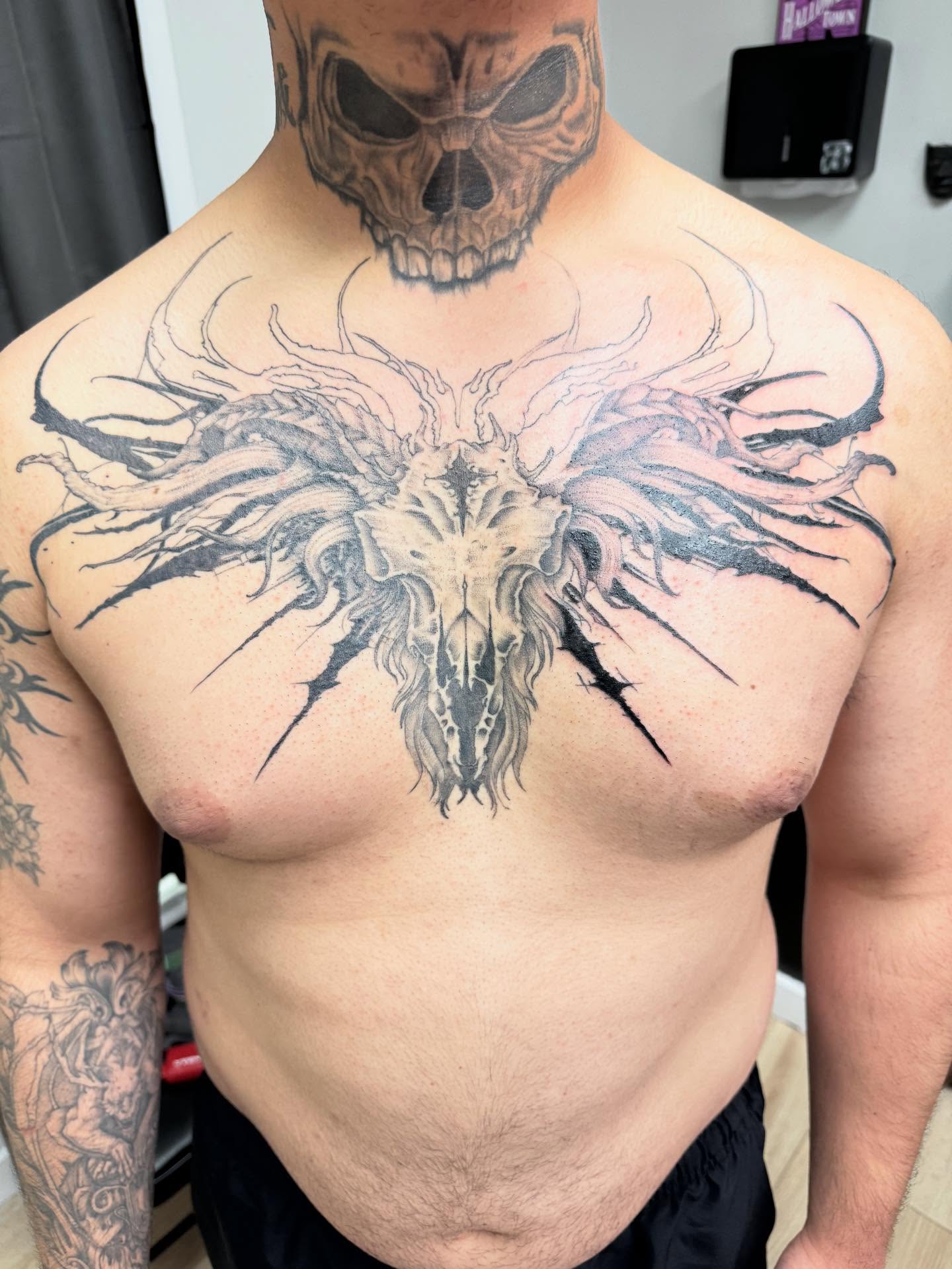 Demon skull dark realism tattoo on the chest by Jon Fleming