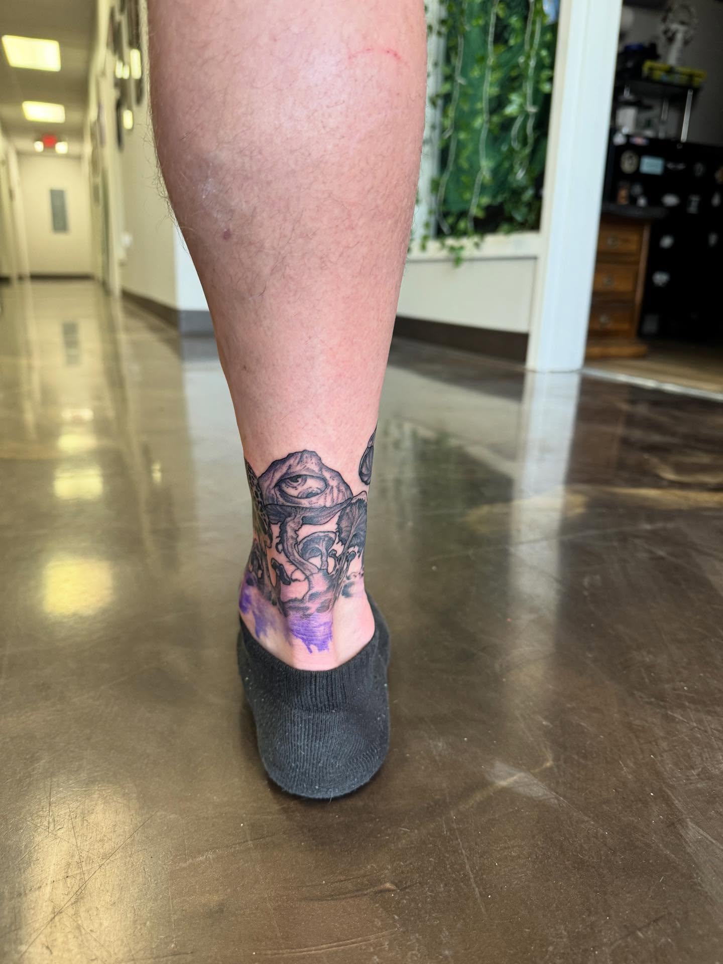 Mask black and grey tattoo on the foot by Jon Fleming