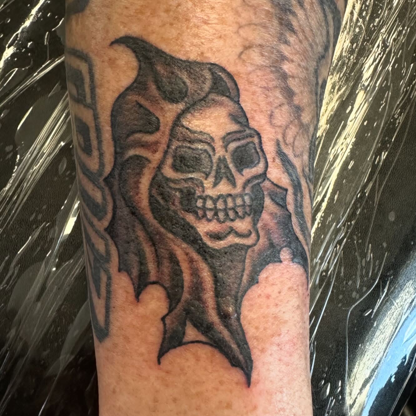 Flaming skull black and grey tattoo on the forearm by Kaylee Woods
