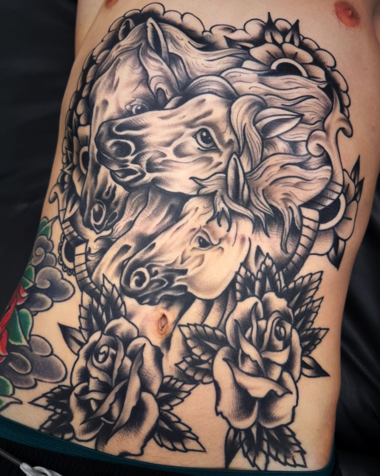 Horses and roses American traditional tattoo on the ribs by Mikey Sarratt