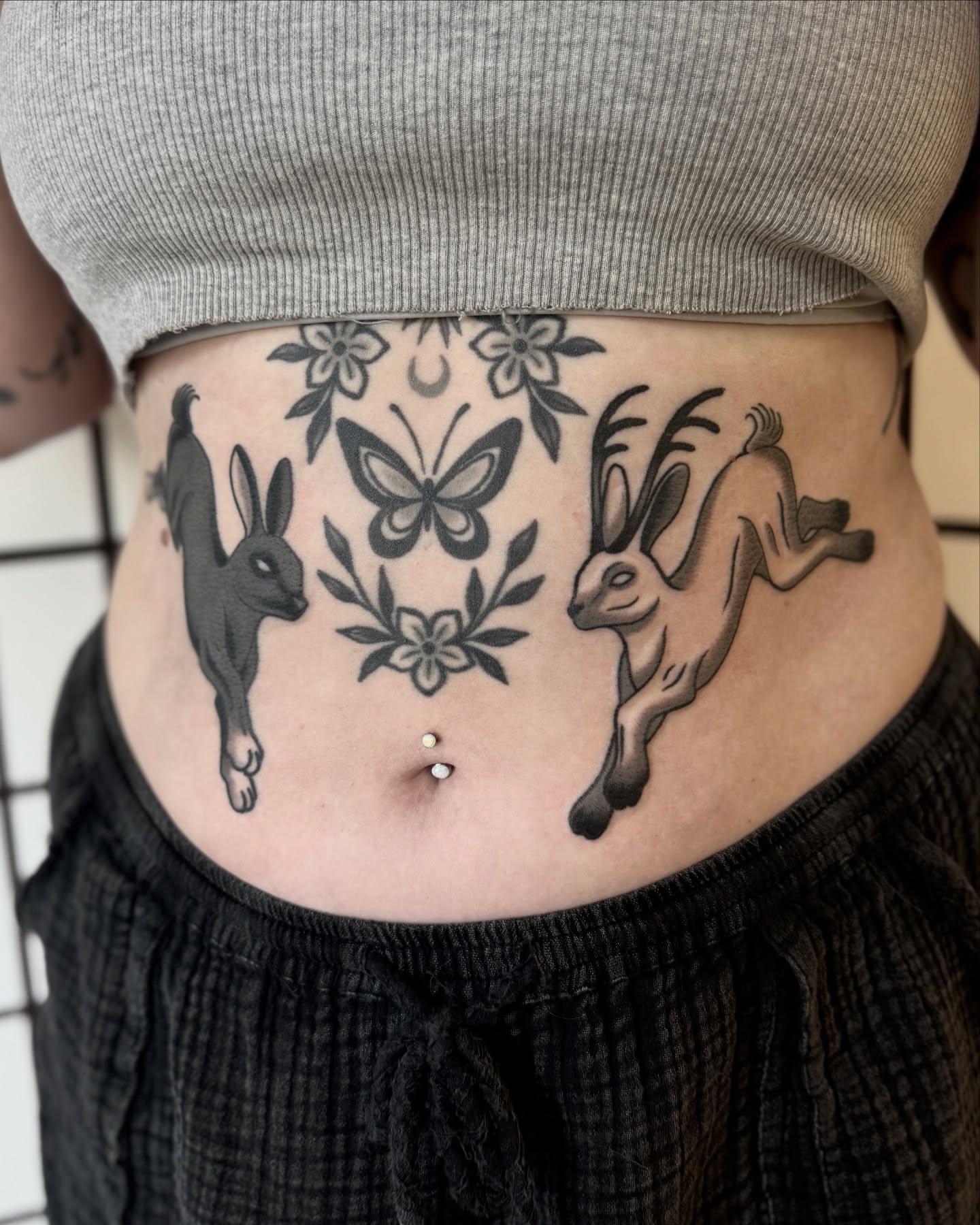 Hoppers and butterfly black and grey tattoo on the torso by Nia (Knee-uhh) 🦷