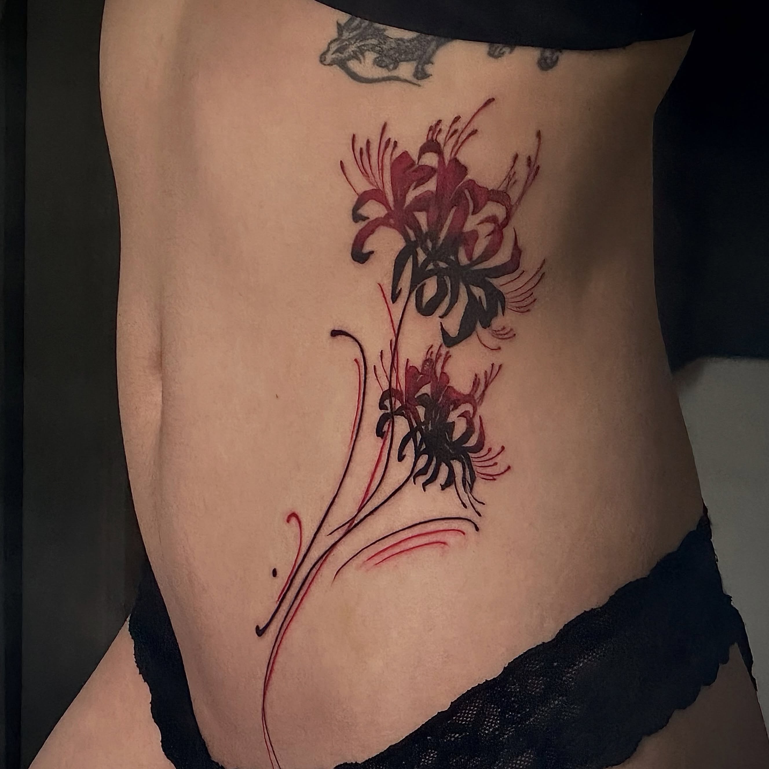 Lilies black and grey tattoo on the ribs by Dante Singh