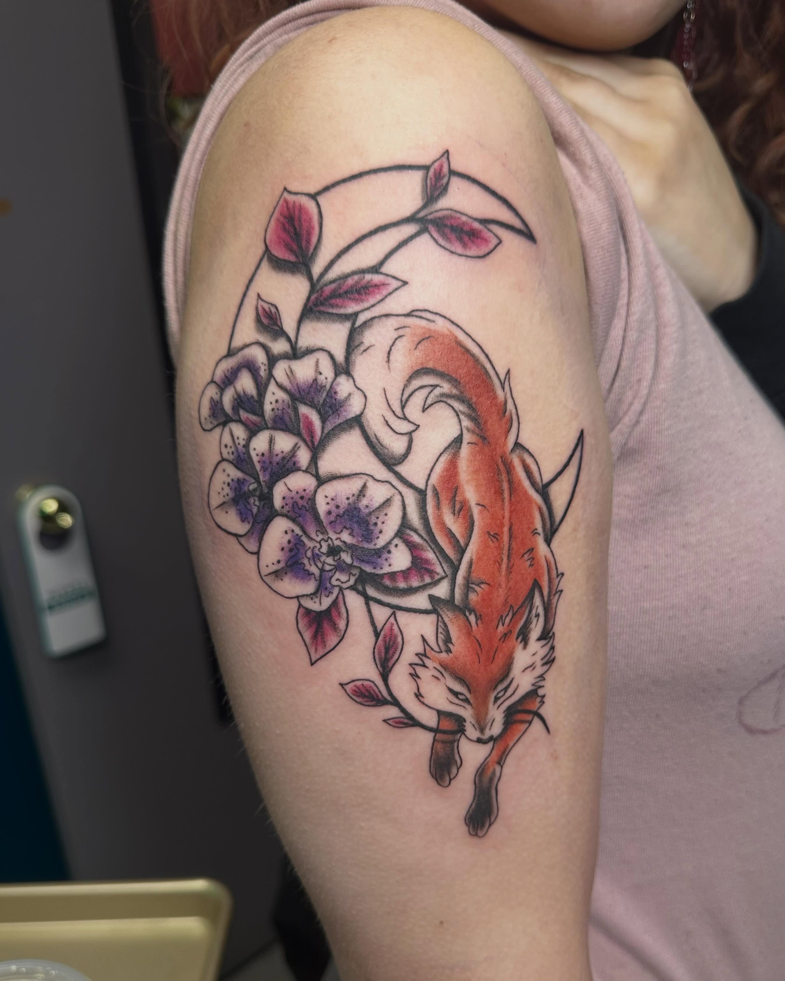 Fox and flowers realism tattoo on the upper arm by Mikaila Jean