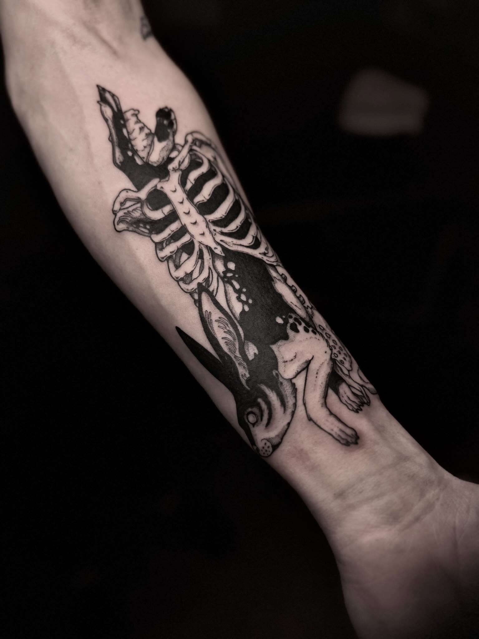 Skeleton and rabbit black and grey tattoo on the forearm by 𝐋𝐢𝐬𝐚 𝐊𝐨𝐫𝐳𝐞𝐧𝐨𝐰𝐬𝐤𝐢