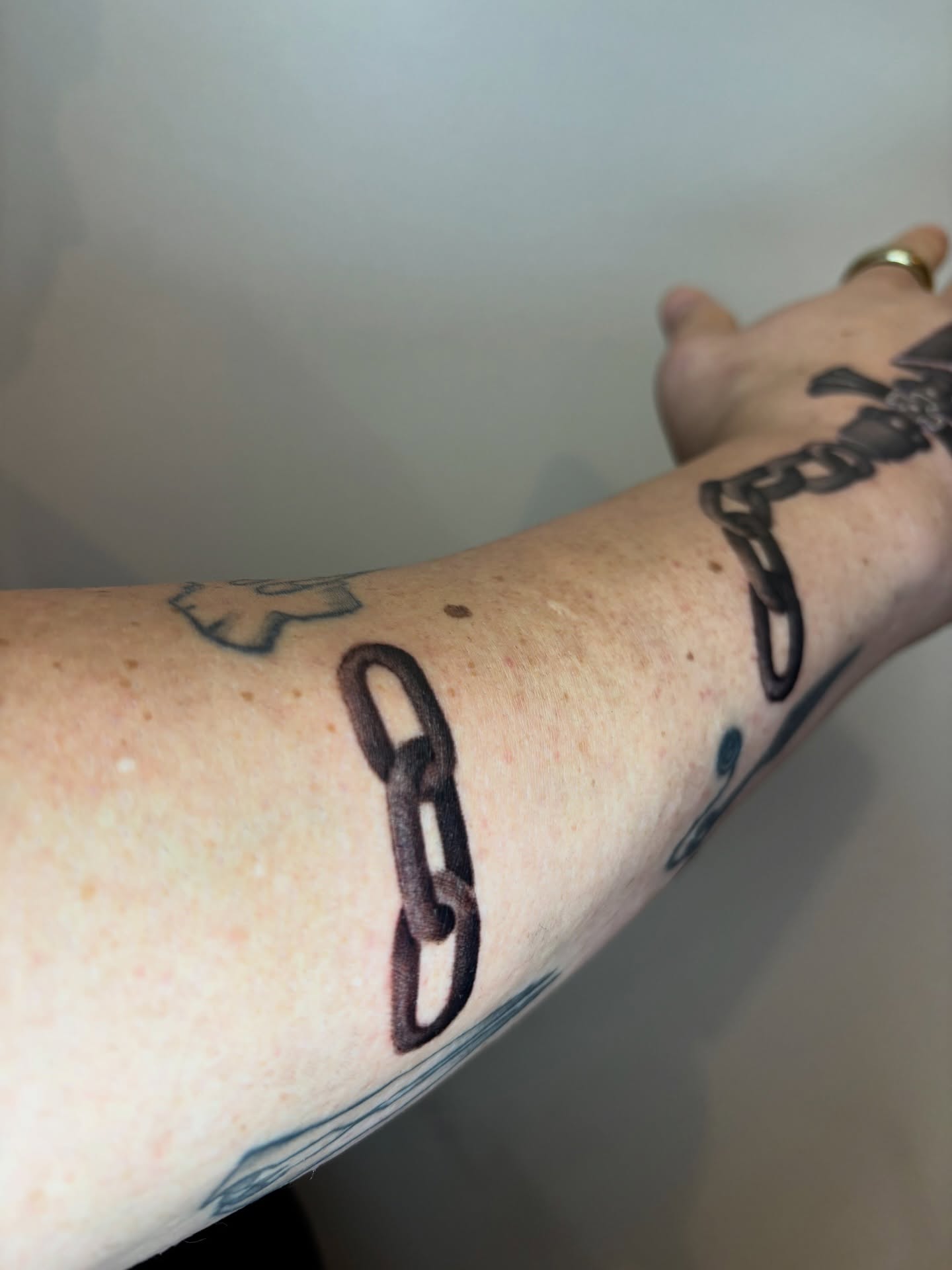 Chain black and grey tattoo on the forearm by Dani