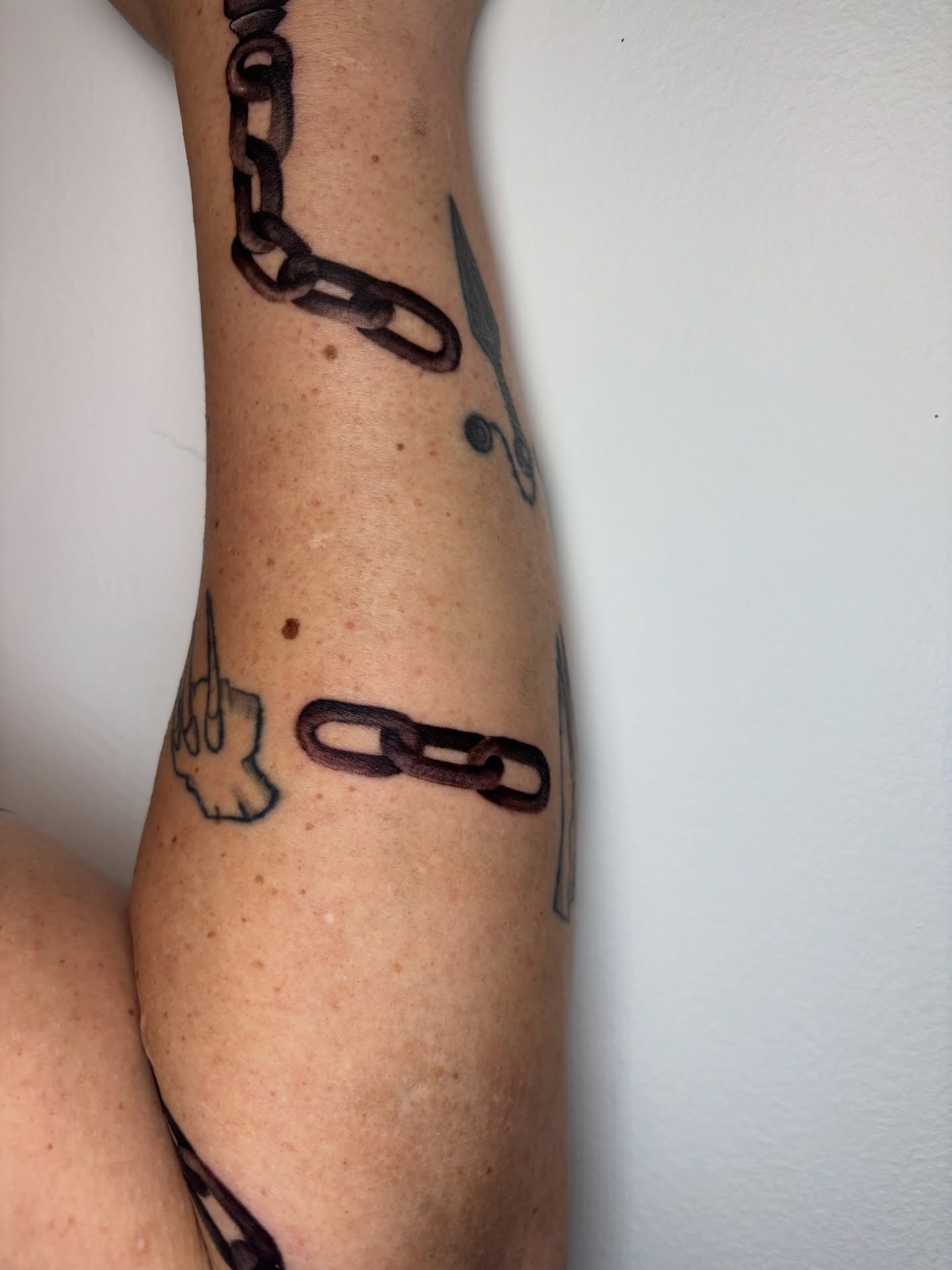 Chains and scissors black and grey tattoo on the forearm by Dani