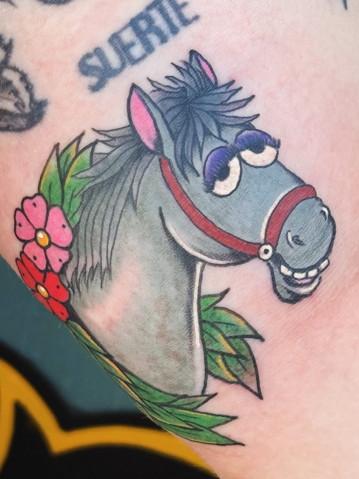 Donkey American traditional tattoo on the upper arm by Megan Sue Causemaker