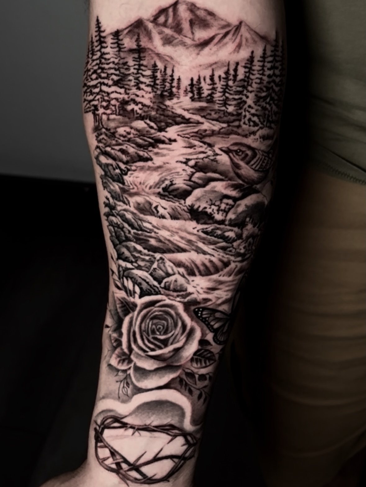 Landscape with bird and rose realism tattoo on the forearm by Dave