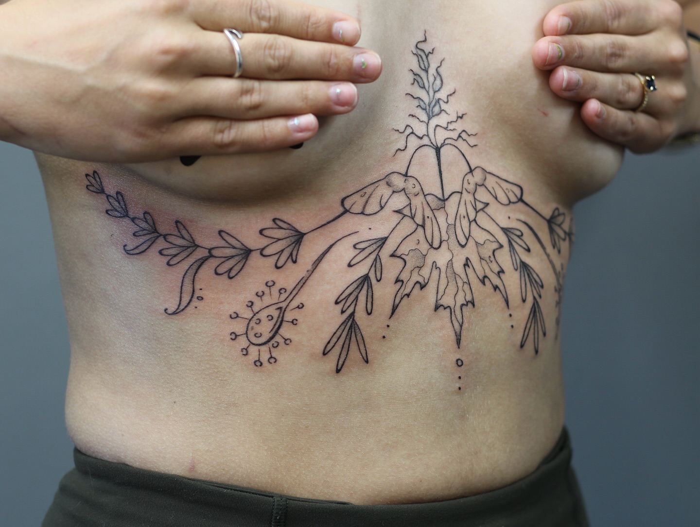 Floral and plant motif black and grey tattoo on the ribs by Amanda Karram