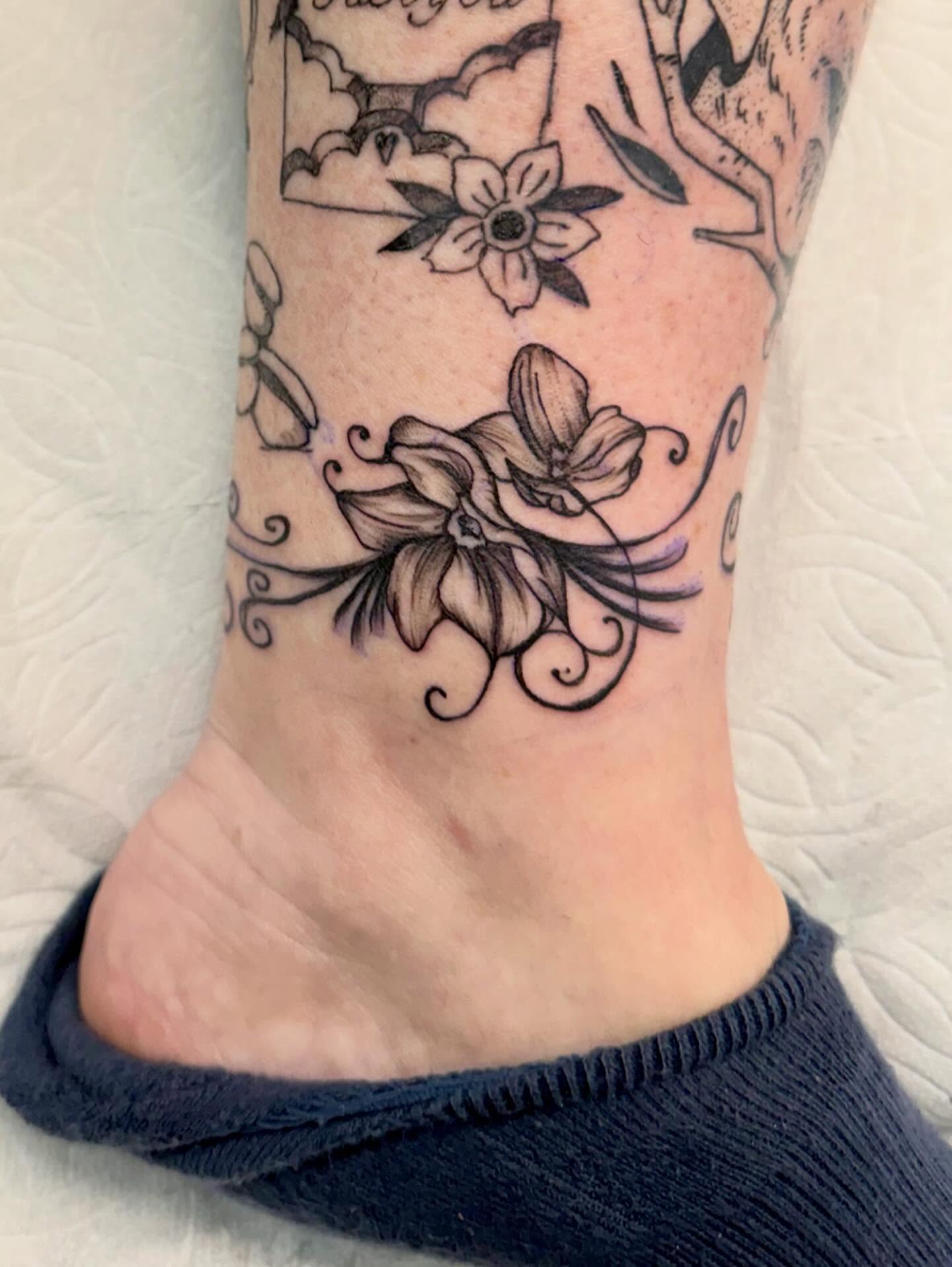 Flowers black and grey tattoo on the foot by Peggy