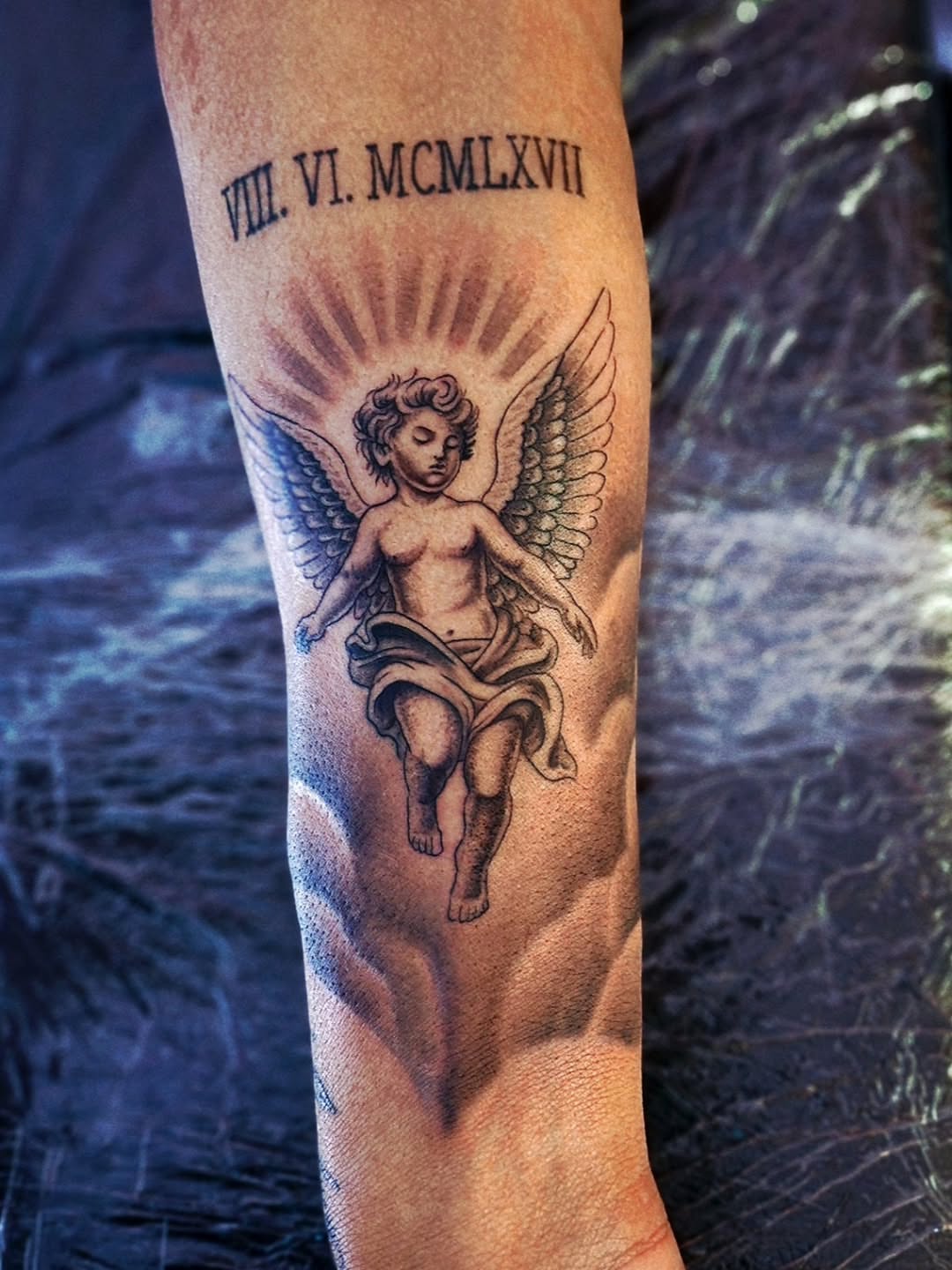Cherub black and grey tattoo on the forearm by Luke Jordan Ink, Louisville, Colorado