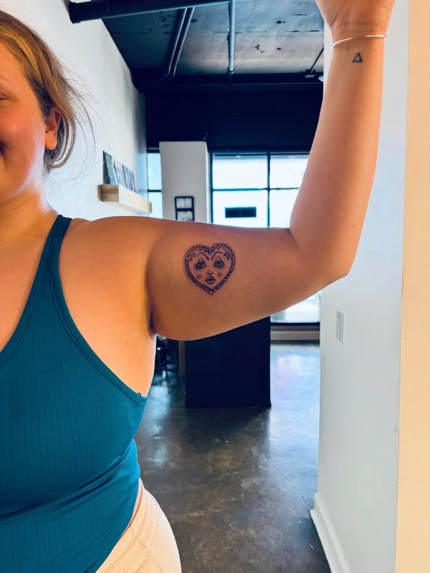Heart with face black and grey tattoo on the upper arm by ★𝐑𝐮𝐞★