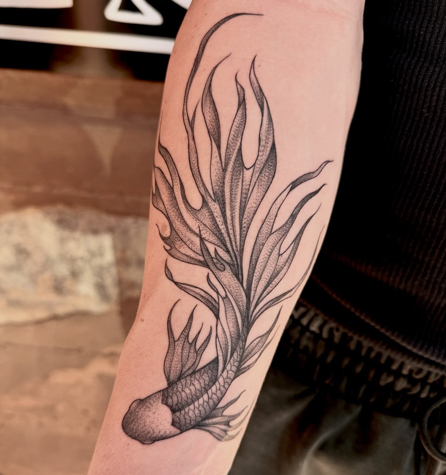 Fish with flames dotwork tattoo on the forearm by Robert McCollum