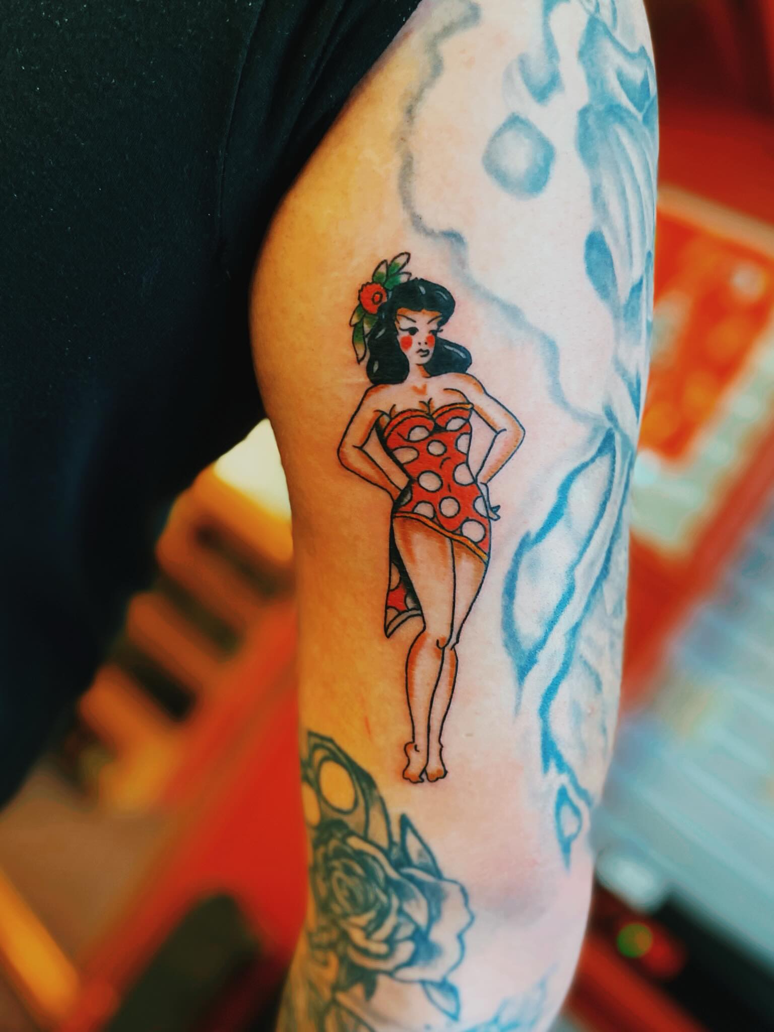 Pin-up girl American traditional tattoo on the forearm by Tommy O'Connell
