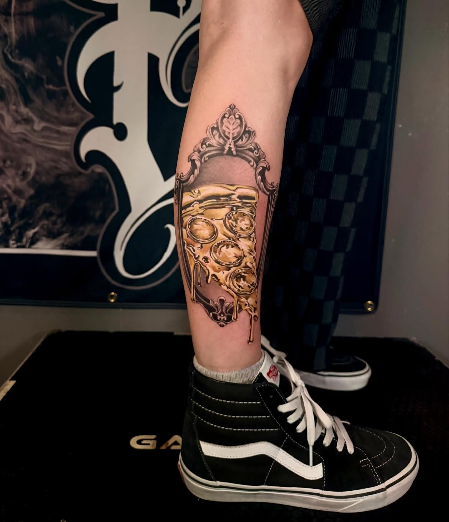 Pizza slice realism tattoo on the forearm by Cody Pappas
