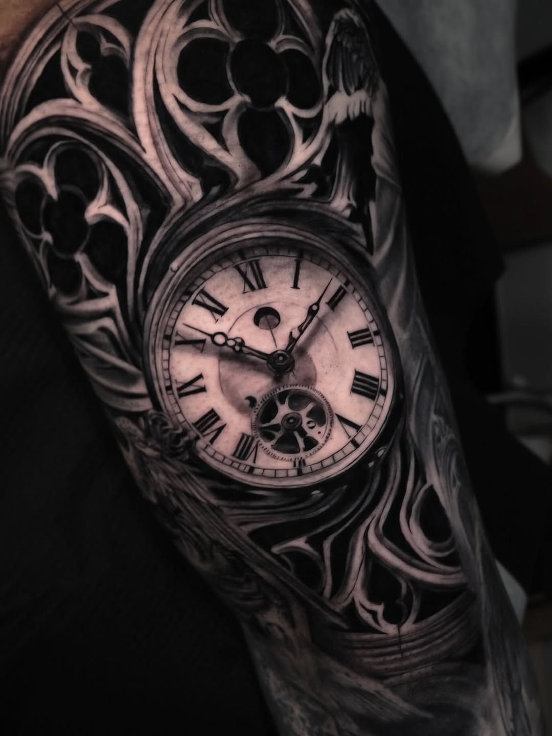 Pocket watch with gothic architecture dark art tattoo on the forearm by Pitasso tattoo black and grey