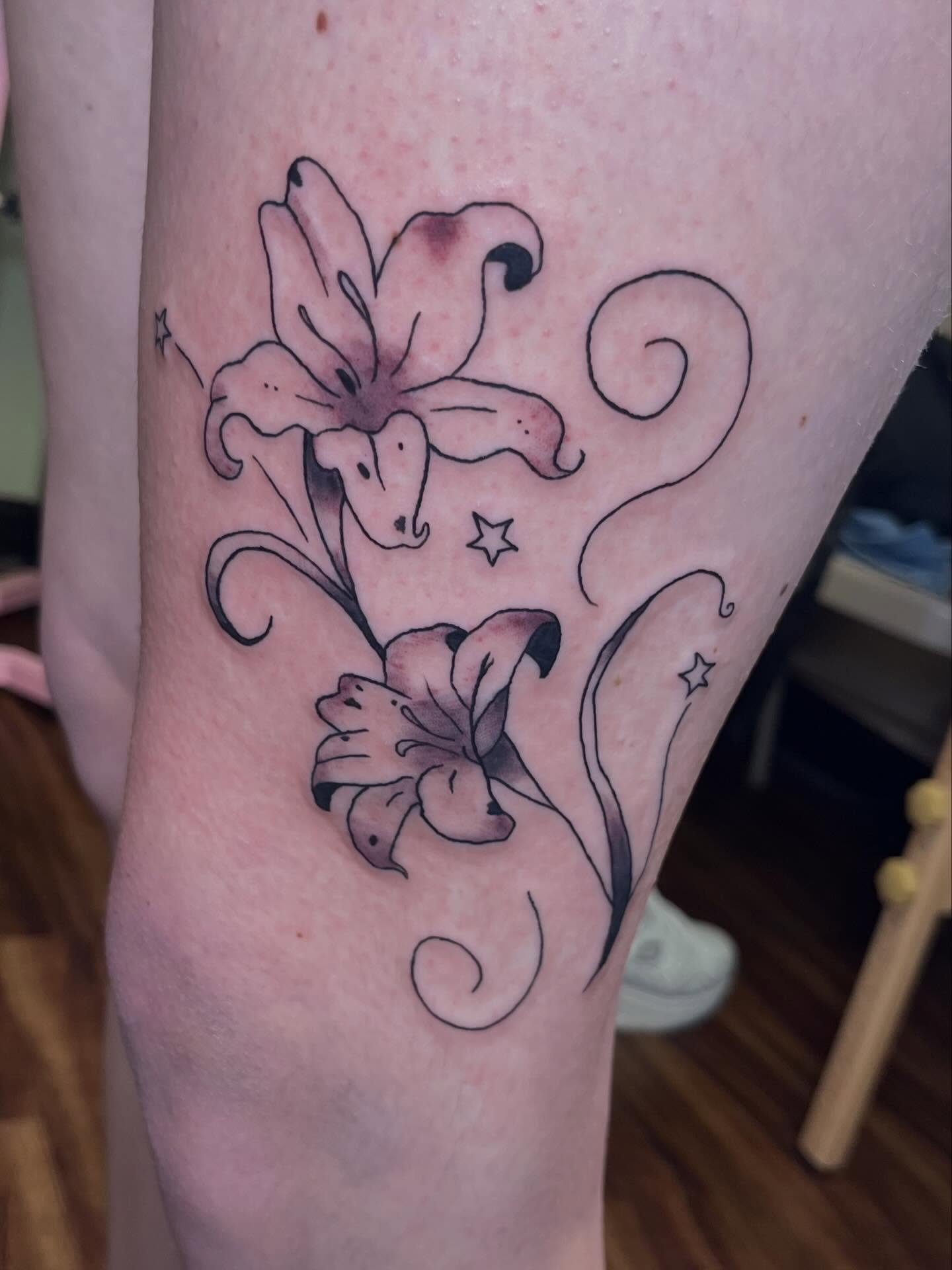 Lilies and swirls black and grey tattoo on the thigh by Jazzy