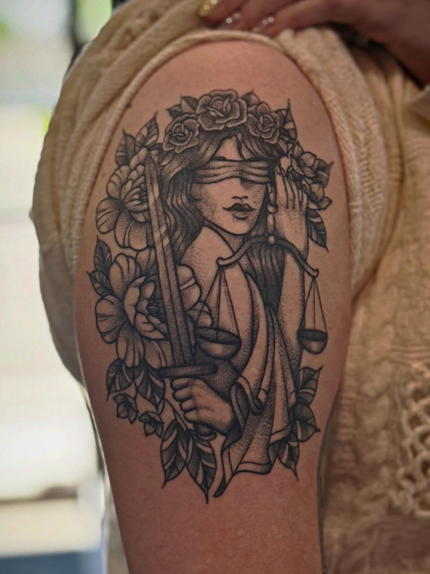 Lady Justice with flowers realism tattoo on the shoulder by Ashley Kayser