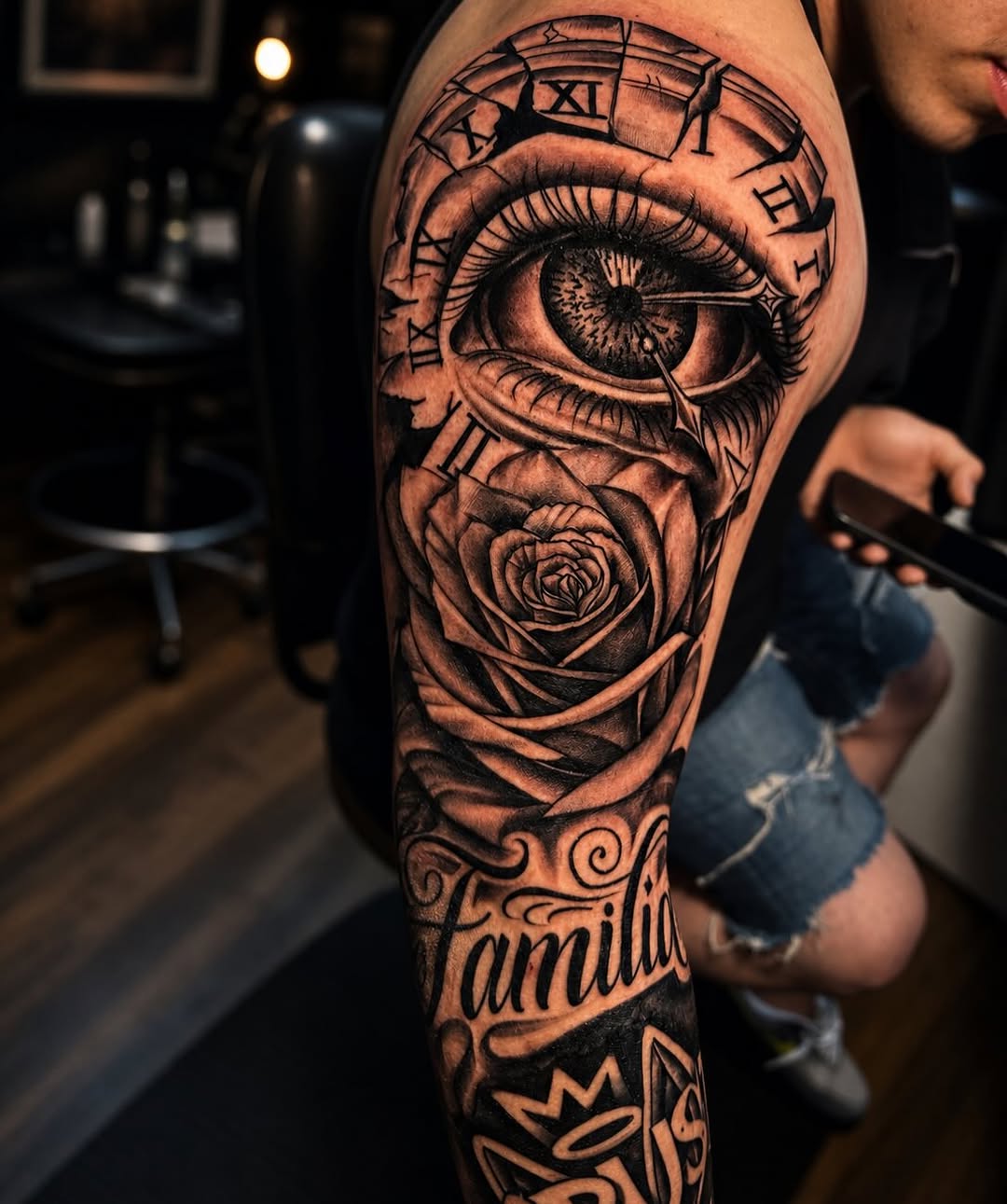 Eye, rose, clock, and lettering surrealism tattoo on the forearm by PMU Artist