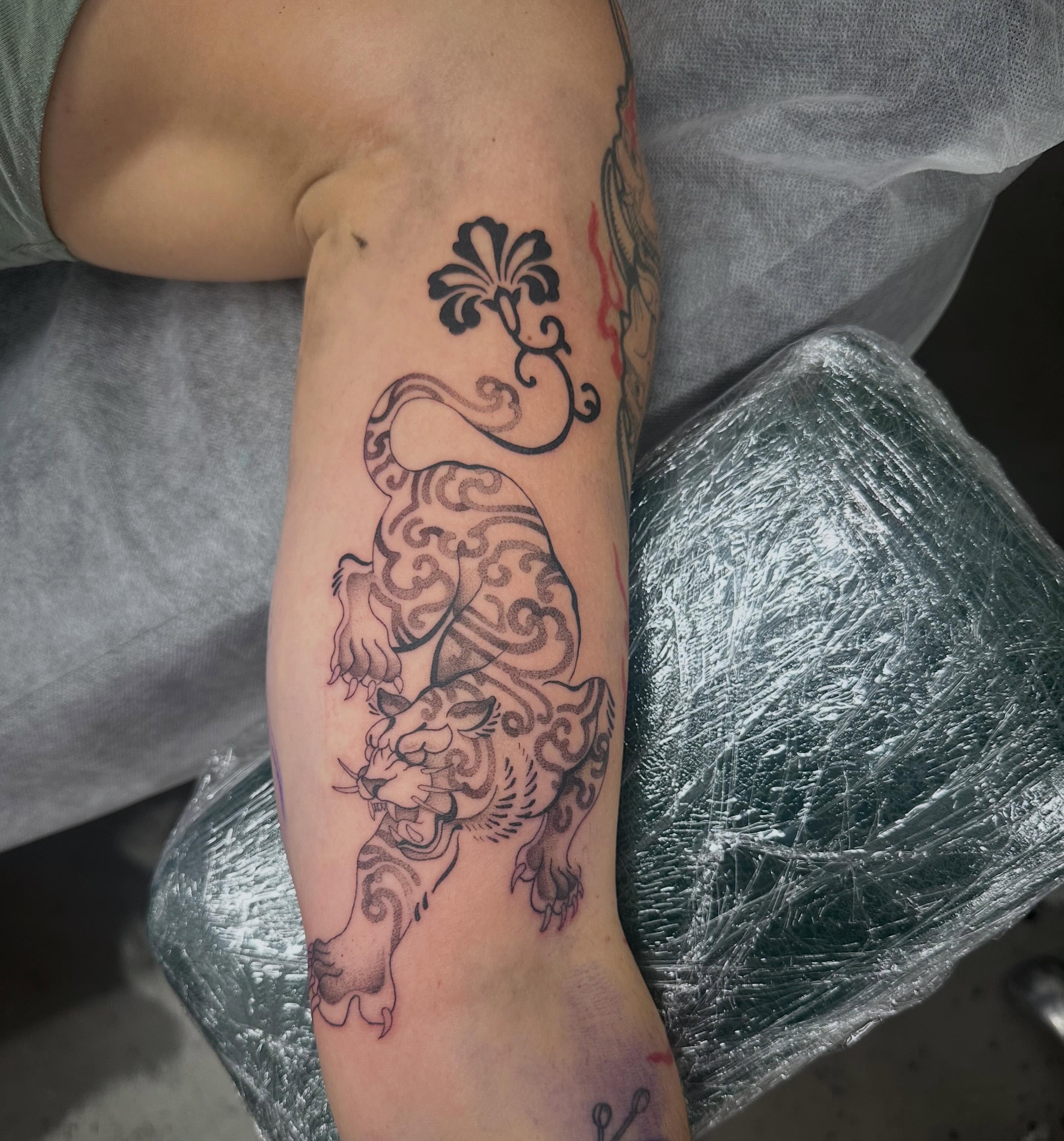 Lion black and grey tattoo on the forearm by Lyndsay Southgate