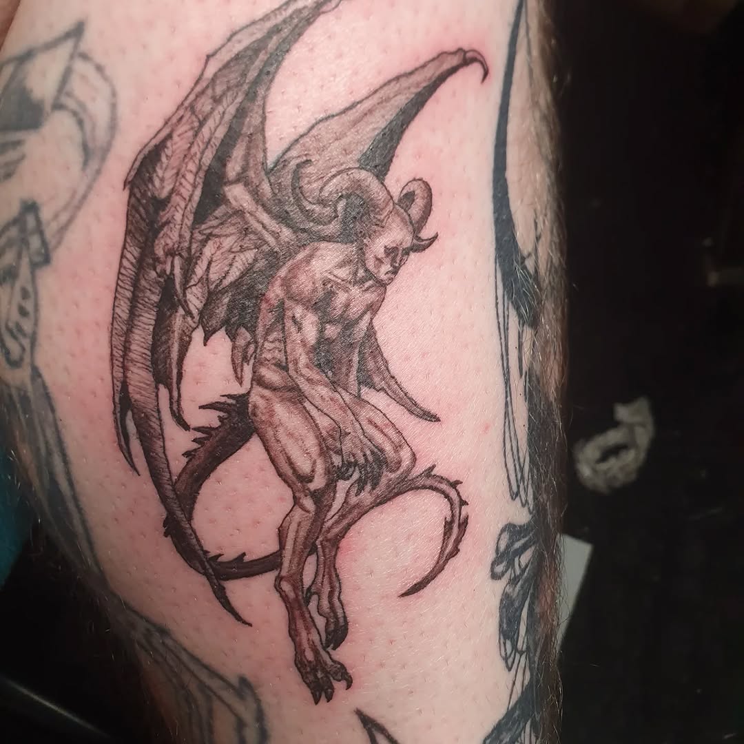 Demon with wings realism tattoo on the upper arm by Artful Ink