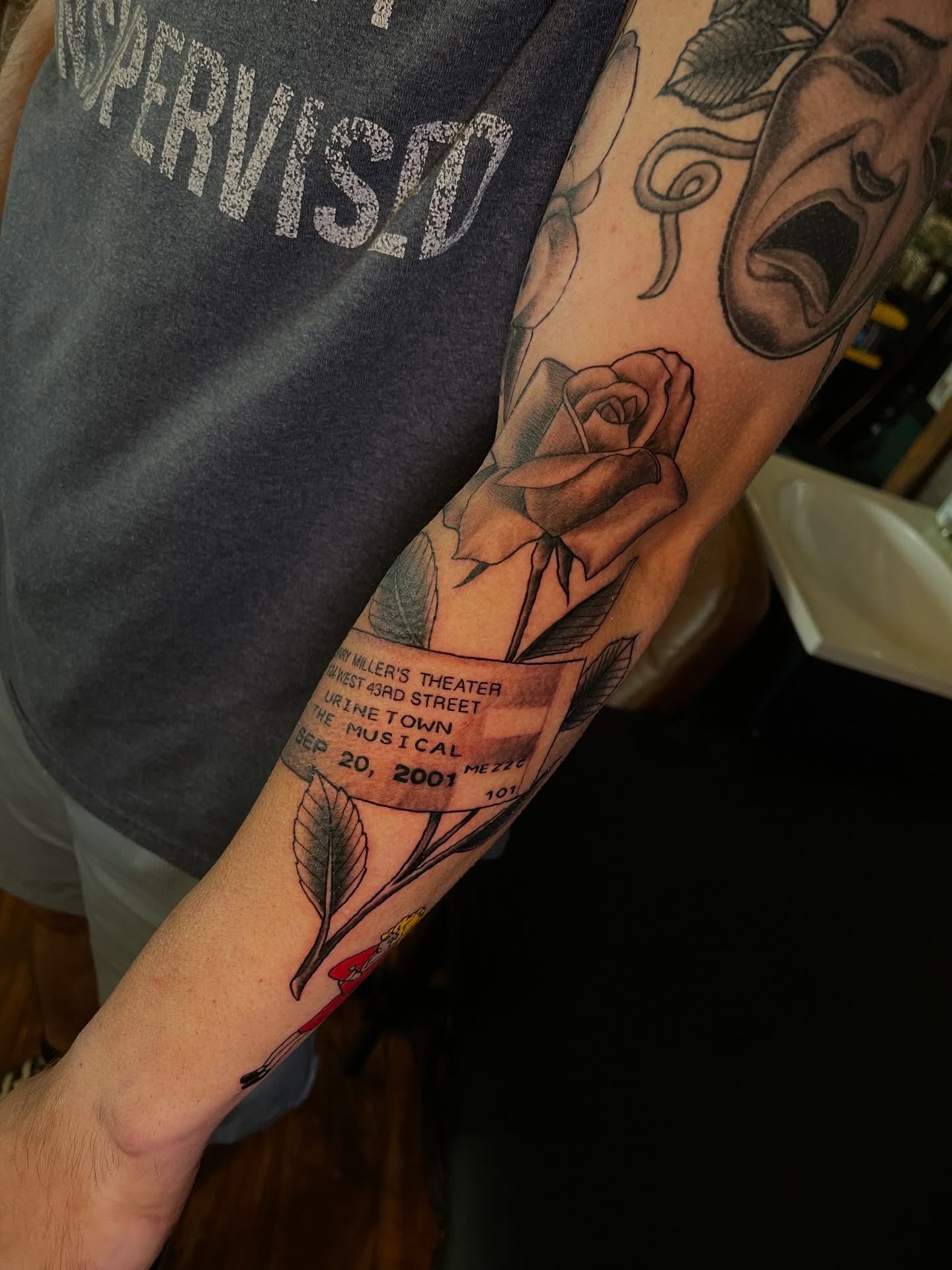 Rose and ticket stub realism tattoo on the forearm by Blake Alan Tattoos (TROUT)