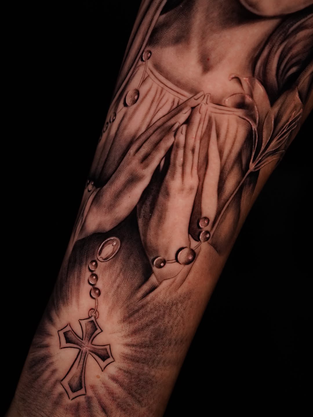 Praying hands with rosary and cross Chicano tattoo on the forearm by Jennifer Garcia
