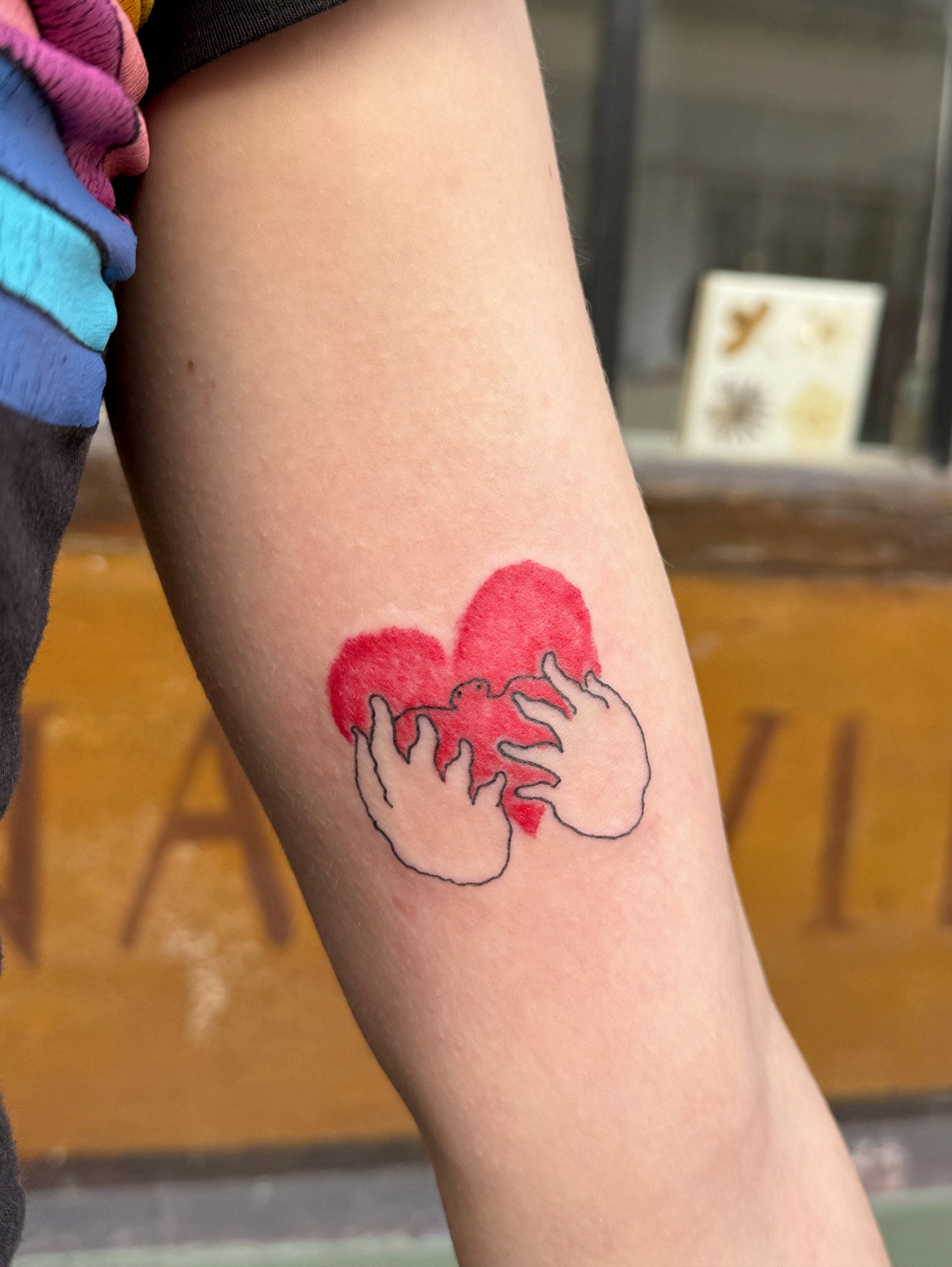 Heart with hands dotwork tattoo on the forearm by Eden Kalif