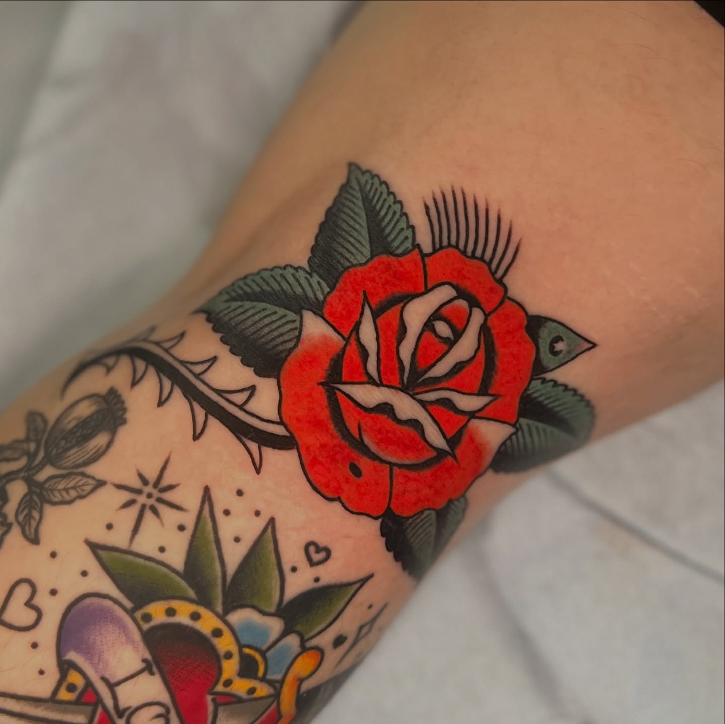 Red rose American traditional tattoo on the forearm by Andrew Storm
