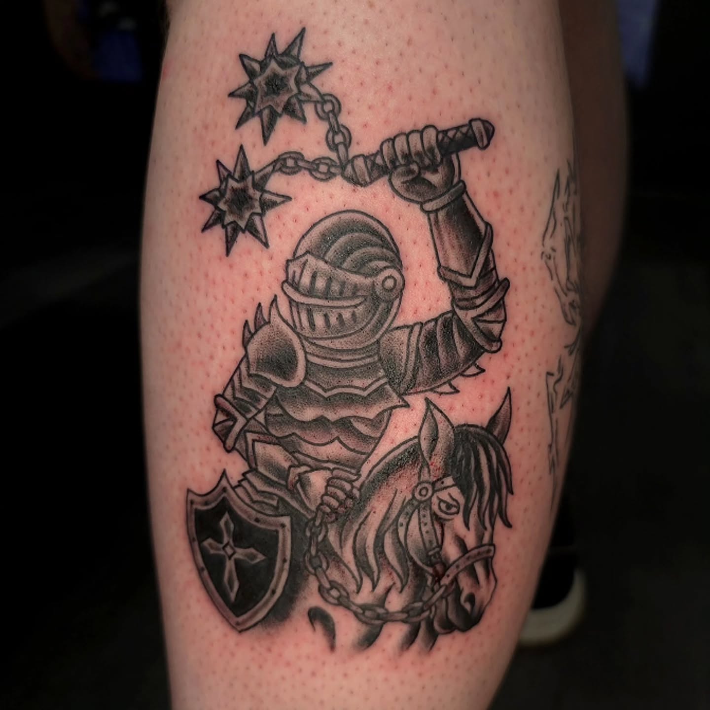 Knight on horseback black and grey tattoo on the thigh by Ian Duncanson