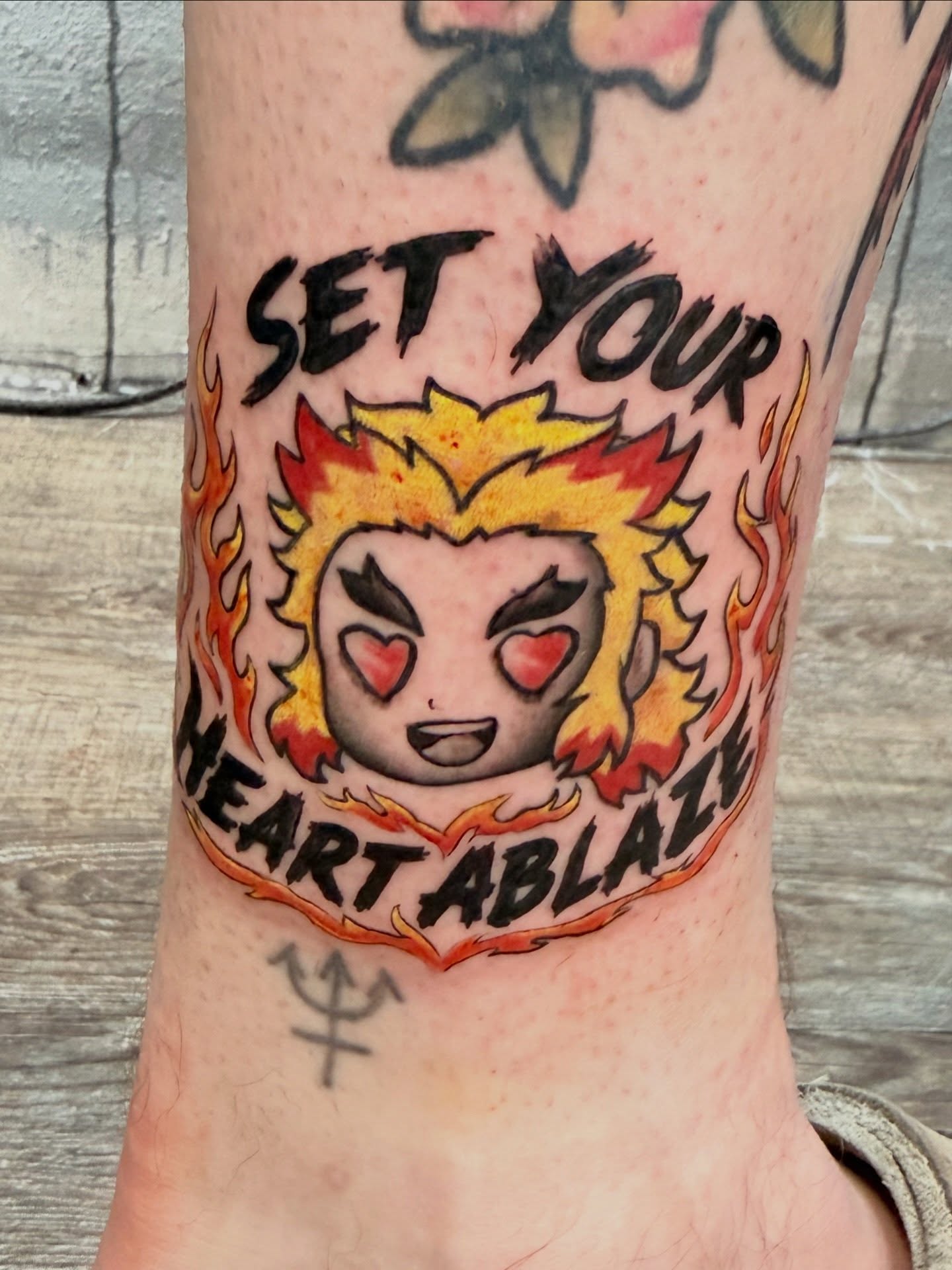 Flaming heart anime tattoo on the forearm by Chris
